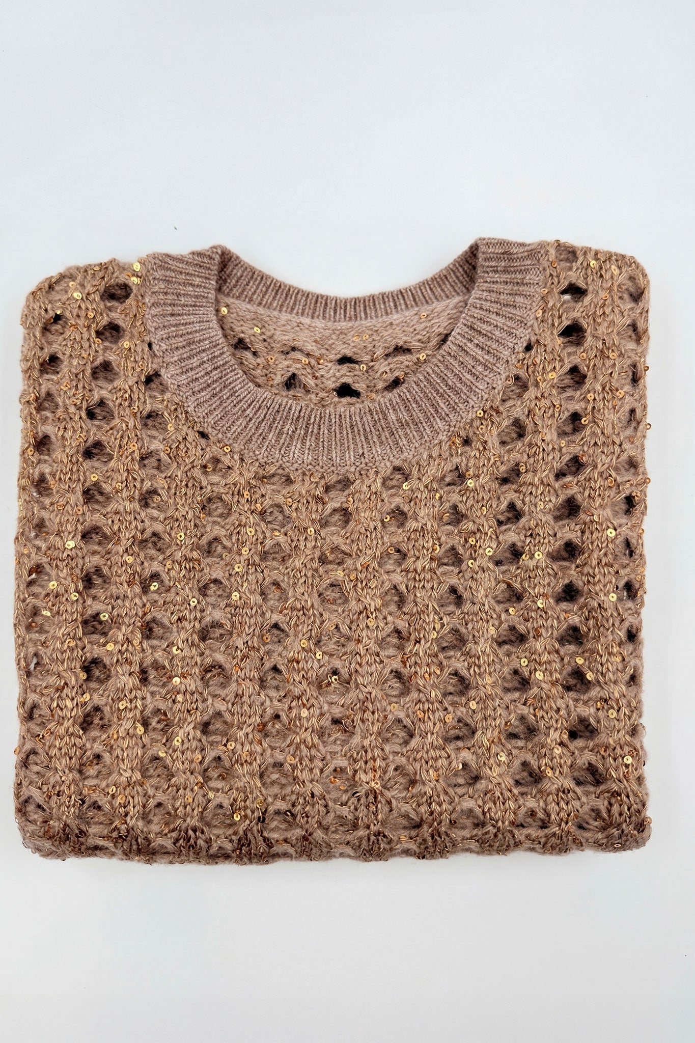 
Détail du dos du pull sans manches en gris taupe, soulignant la texture ajourée et l'éclat des sequins pour un style raffiné.



