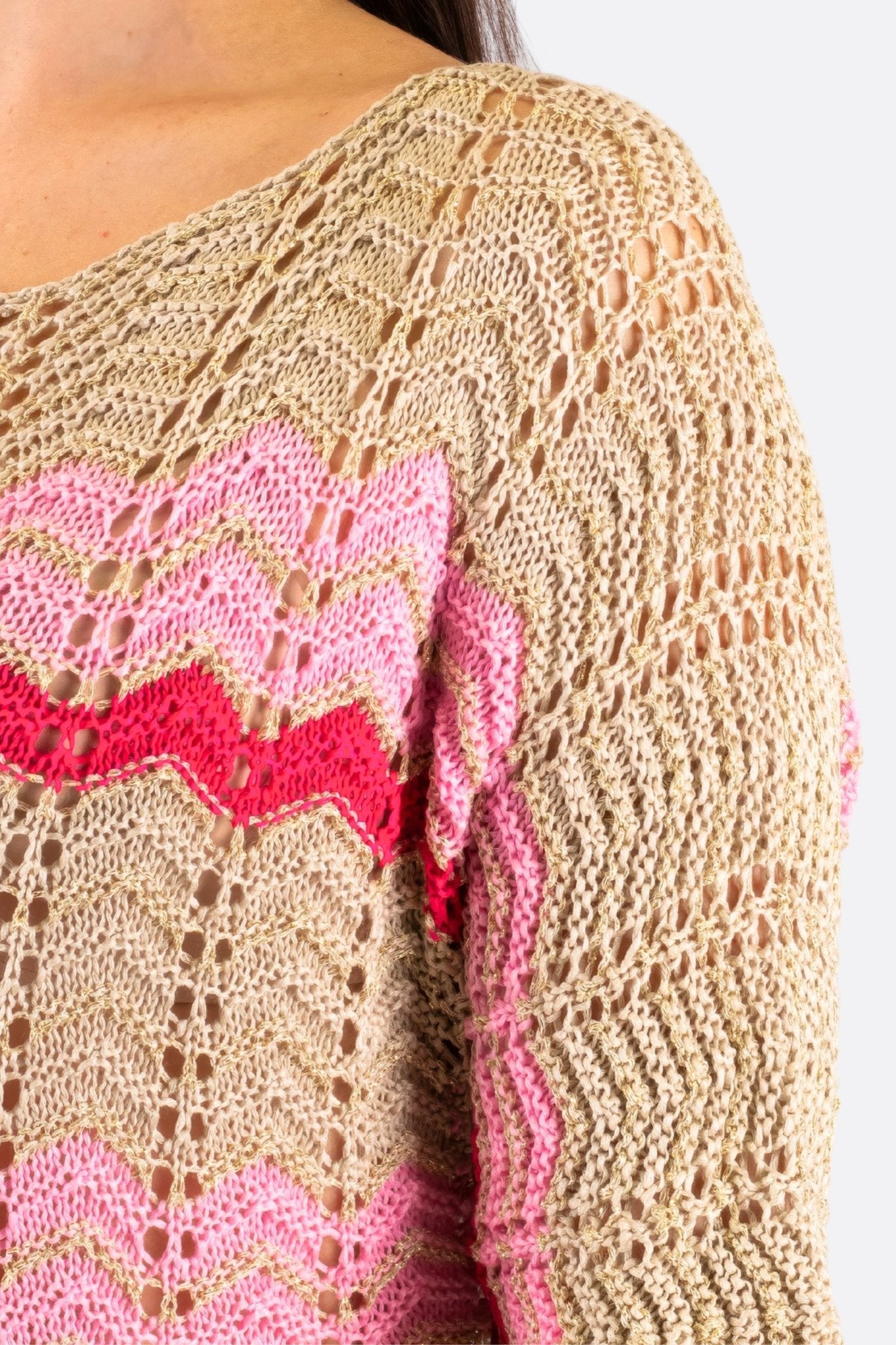 
Détail d'un pull ajouré beige avec motifs chevrons roses, une pièce italienne raffinée pour des occasions distinguées.



