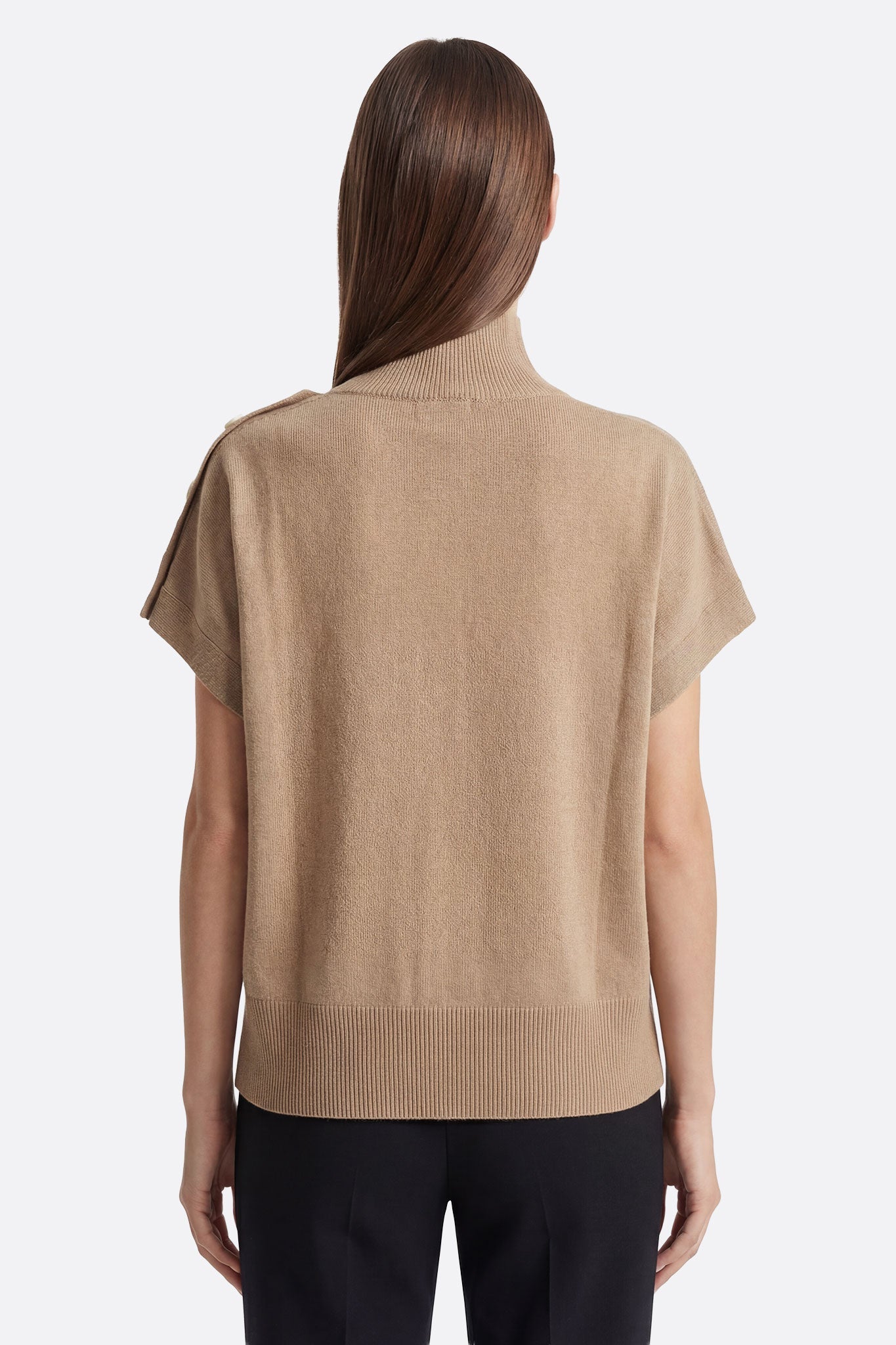
Vue 3/4 du poncho pull beige à col montant boutonné, avec détails raffinés et côtés à pressions pour un style décontracté.



