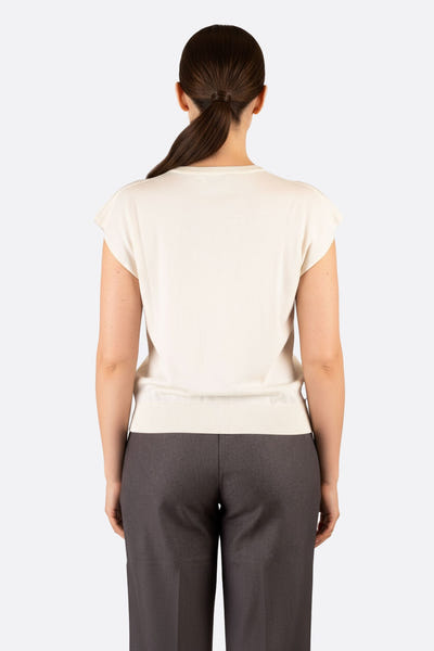 
Détail zoomé sur le pull blanc en maille légère, idéal pour une soirée élégante ou un look décontracté.



