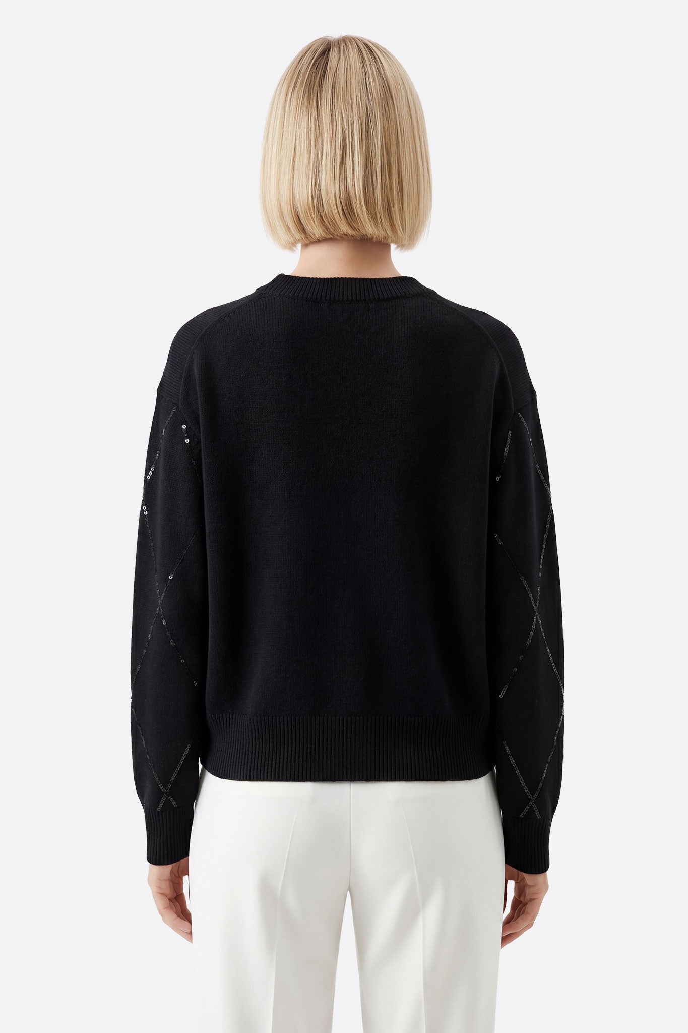 Suéter negro de lana con toques brillantes, ideal para un look elegante y sofisticado en cualquier evento.