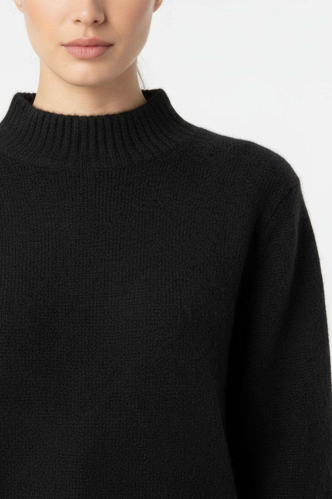 Pull noir pour femme en mohair à col montant, mettant en avant une texture douce et une élégance intemporelle pour tous...