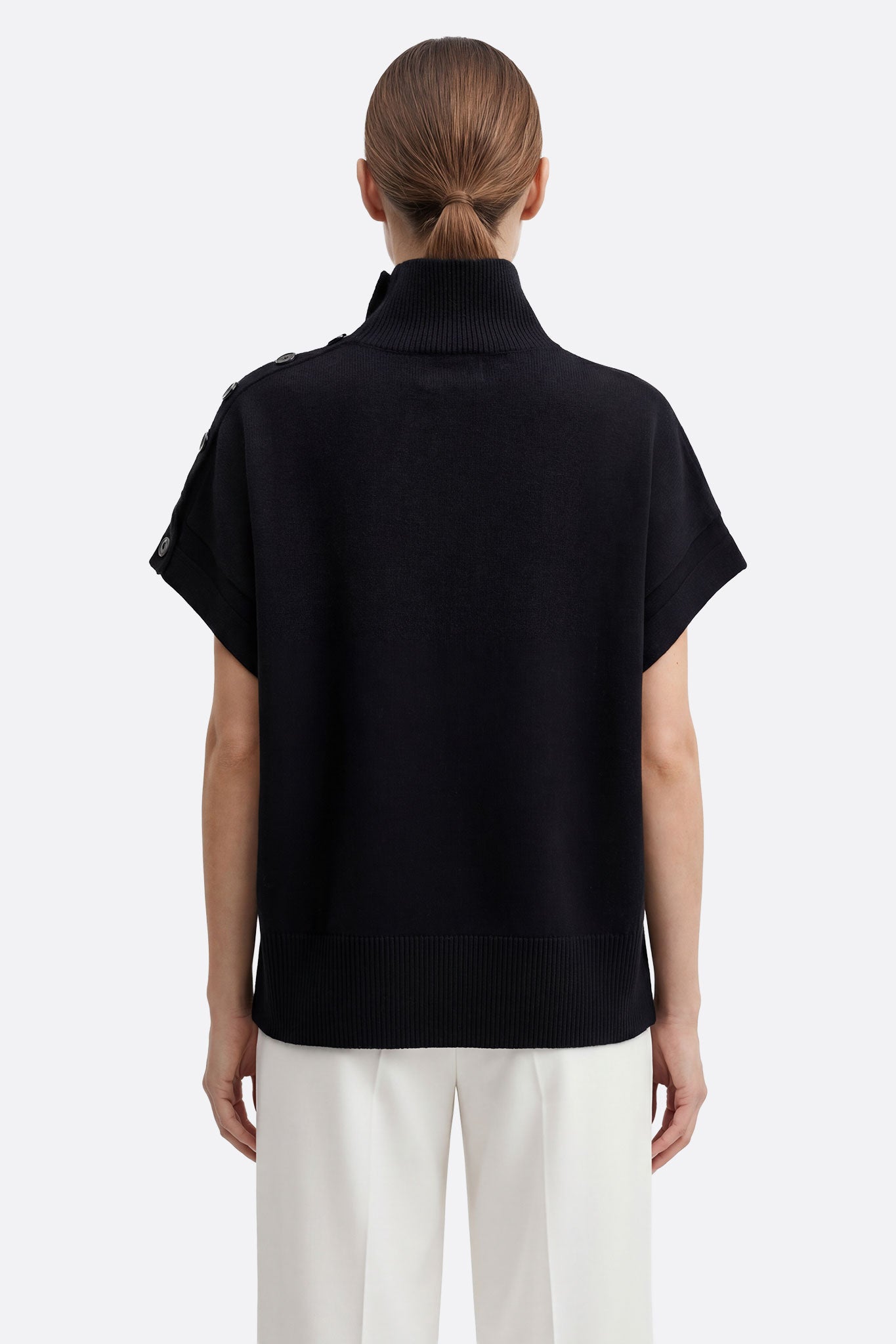 
Profil du pull noir oversize à col montant, mettant en avant sa matière texturée et son allure parfaite pour les soirées...



