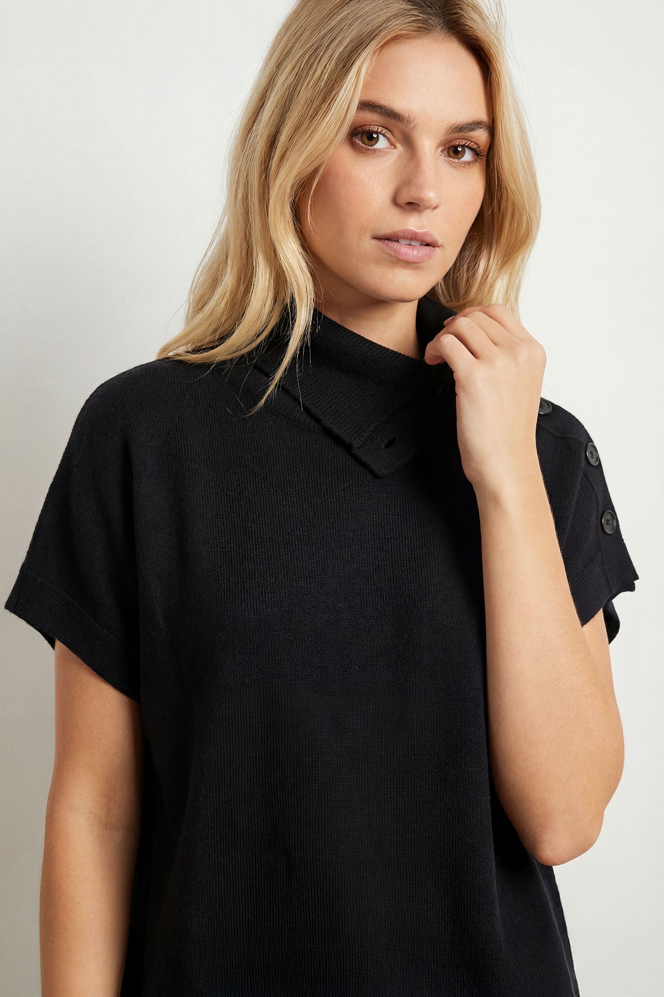 
Détail du dos du pull noir à col montant avec boutons, présentant sa texture en maille douce et sa coupe ample raffinée.



