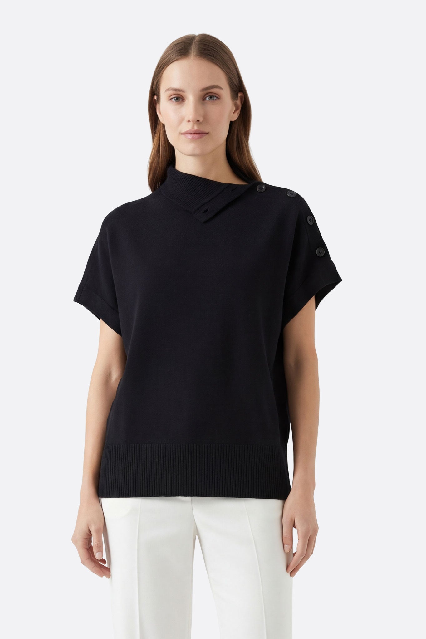 Pull noir à col montant boutonné porté de face, mettant en avant sa coupe oversize et sa maille douce pour un look chic.