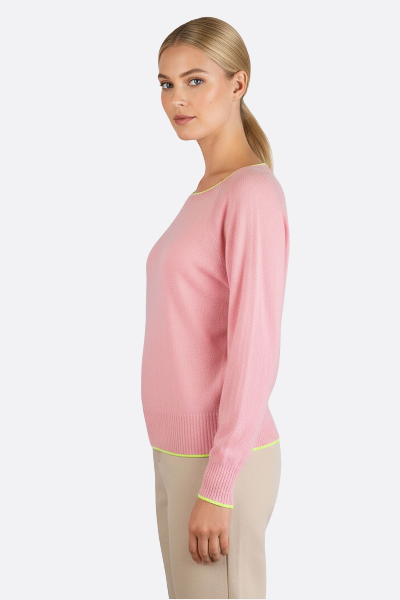 Détail du pull rose en laine mérinos et cachemire, mettant en valeur les finitions jaune fluo pour un look moderne.