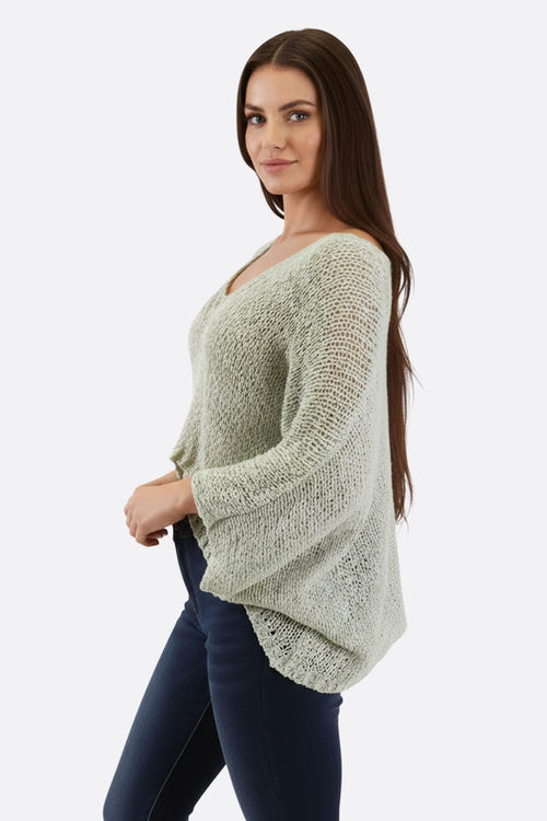 
Détail sur le pull en maille ajourée turquoise, mettant en avant la texture et la légèreté, idéal pour un look élégant.



