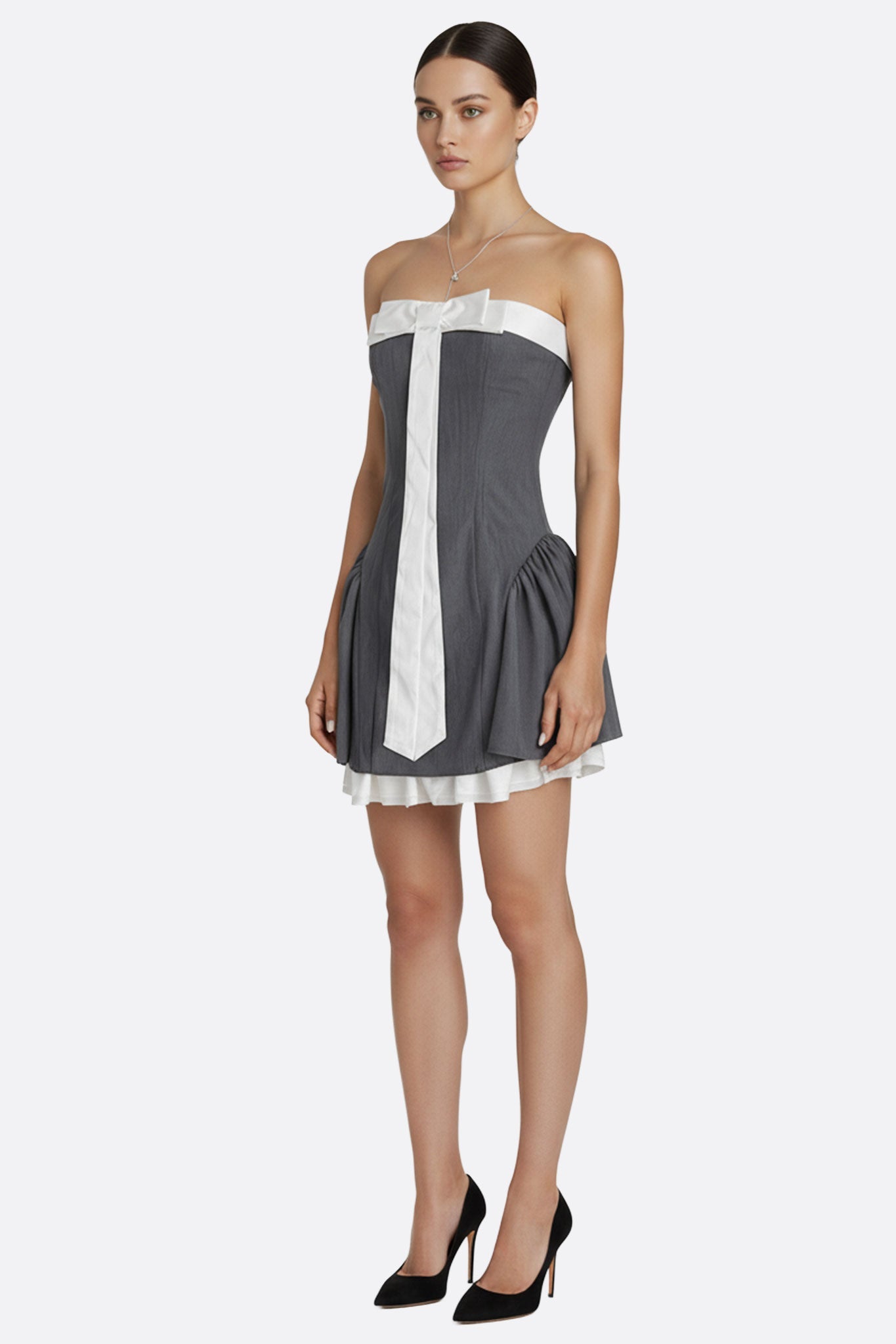 
Perspective 3/4 de la robe bustier grise ornée d'un élégant nœud blanc, un choix parfait pour des occasions sophistiquées.



