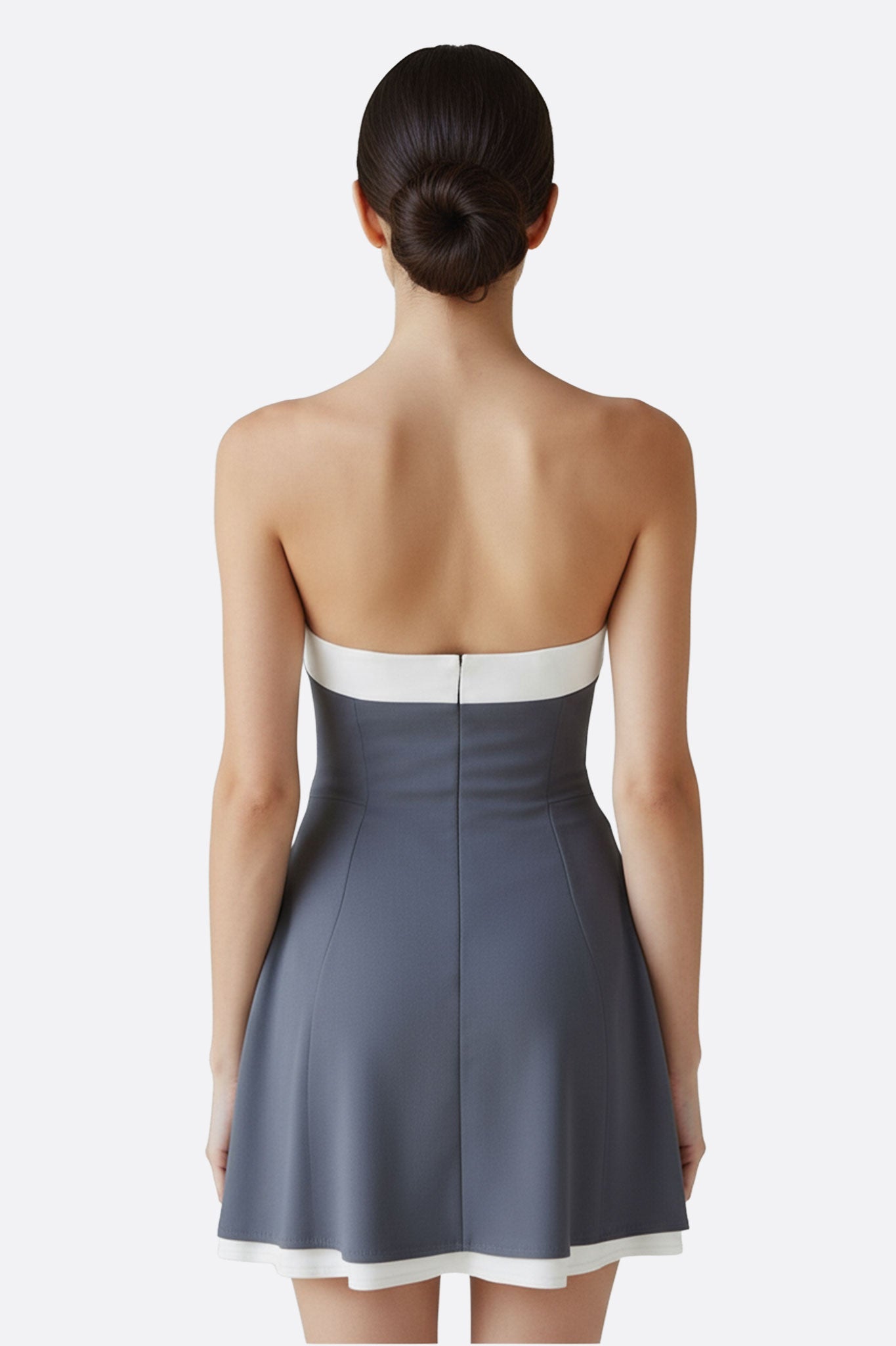 Détail de la robe grise bustier courte, mettant en avant le nœud blanc élégant et la texture raffinée du tissu.