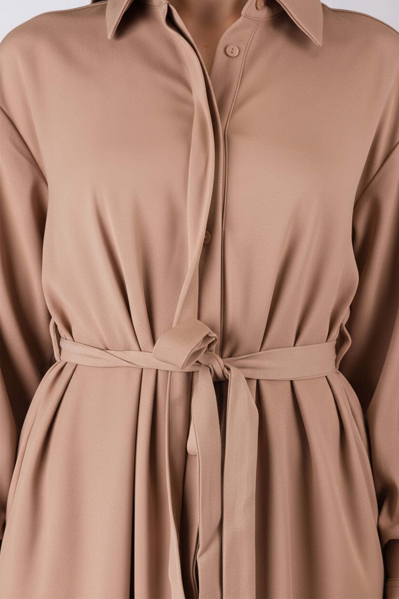 
Détail alternatif de la robe chemise beige camel, ceinture à la taille, offrant une silhouette raffinée et élégante.



