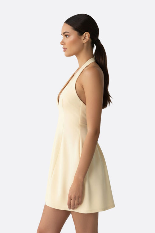 
Zoom sur le décolleté profond d'une robe courte beige évasée, idéale pour sublimer une silhouette élégante.



