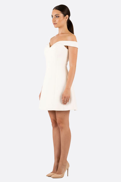 
Détail élégant de la robe courte ivoire à coupe trapèze, mettant en avant le bustier et les épaules dénudées.



