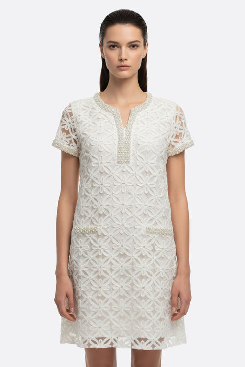 
Profil élégant d'une robe courte blanche avec broderie florale perlée, parfaite pour une tenue chic en journée.



