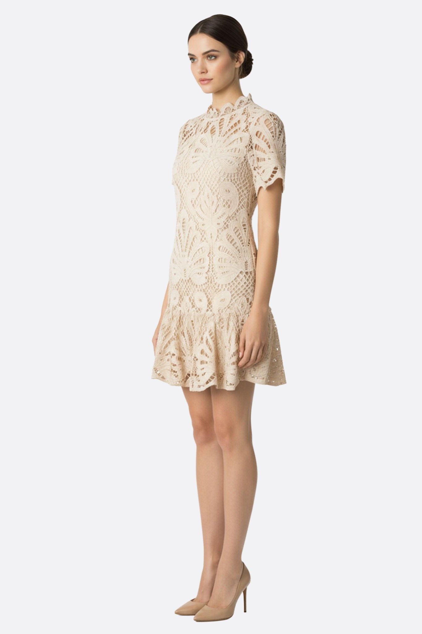 Détail délicat de la robe courte en dentelle nude, révélant sa texture ajourée pour un style raffiné et sophistiqué.