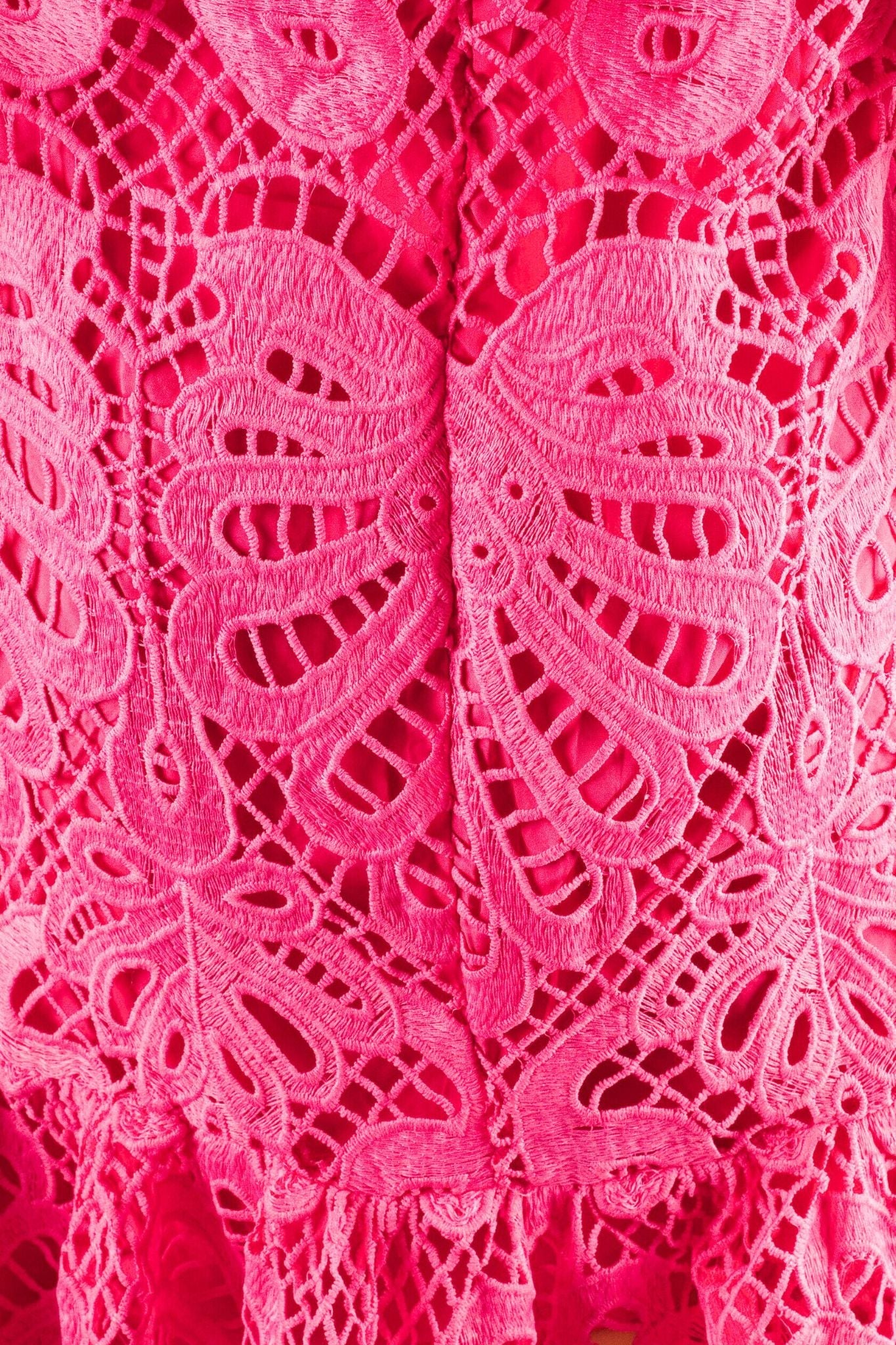 
Détail du dos de la robe courte en dentelle fuchsia, révélant le jeu de textures et le style audacieux pour une allure chic.



