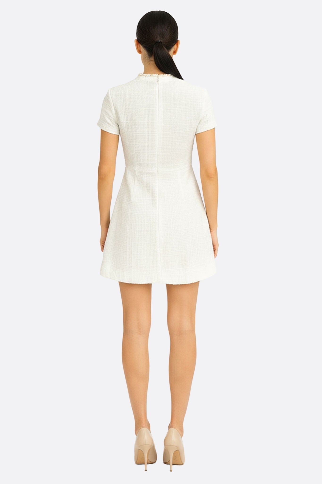 Détail élégant de la robe courte en tweed ivoire à col perlé doré, révélant sa sophistication pour une occasion spéciale.