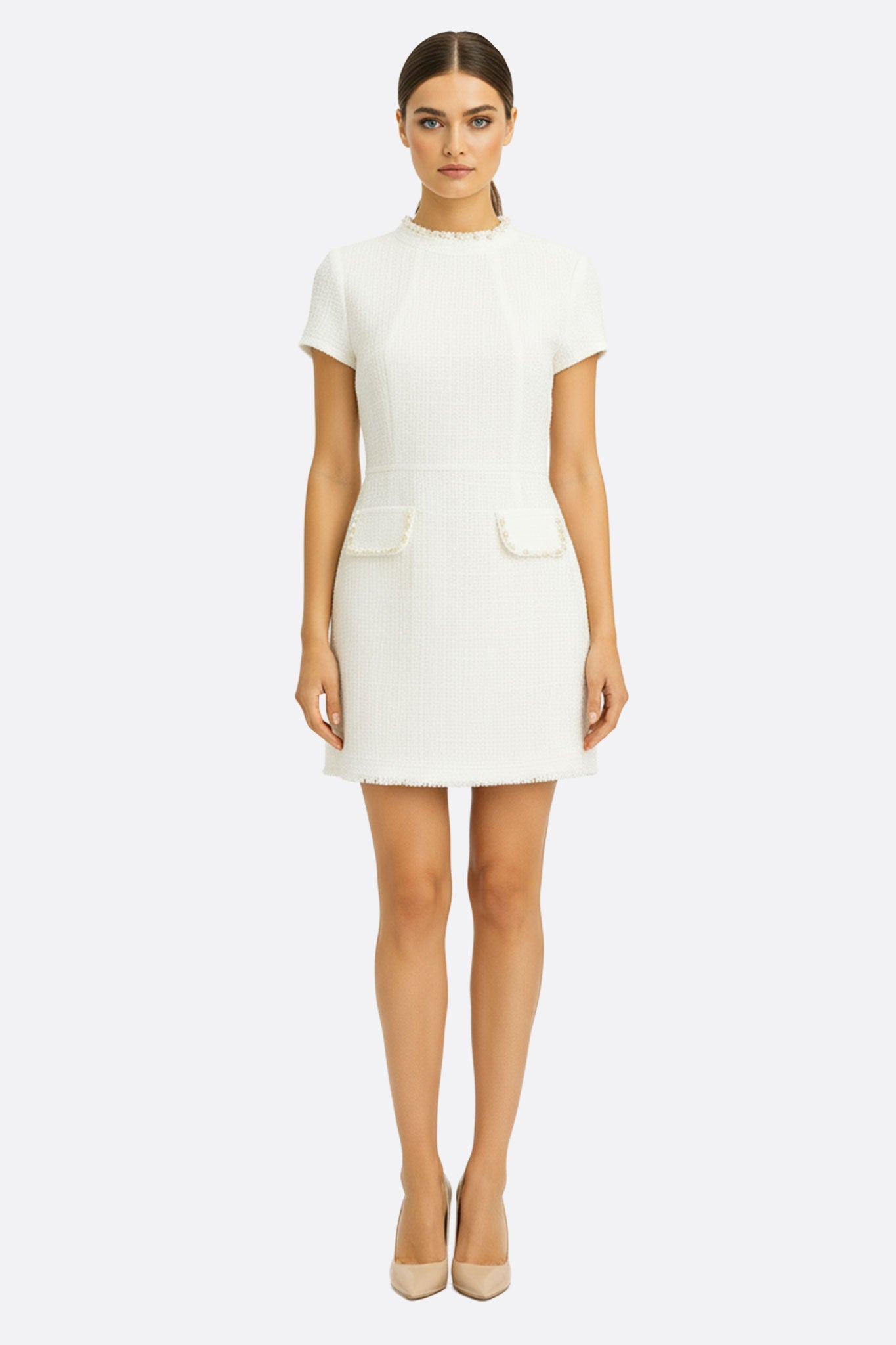 Détail du col perlé doré sur une robe courte en tweed ivoire, idéale pour un look chic et sophistiqué.