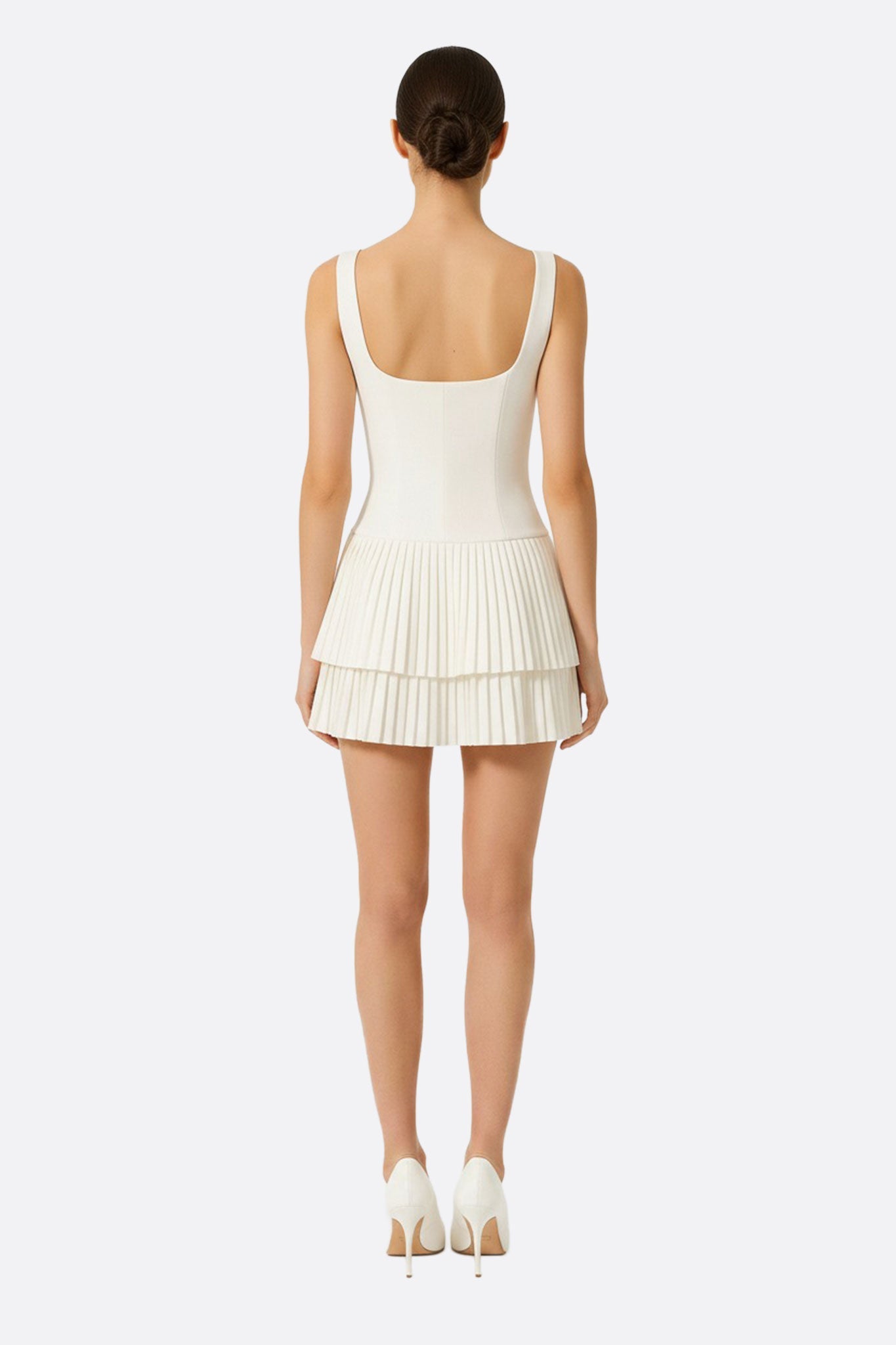 
Robe blanche courte à jupe évasée, mise en valeur par un angle inédit, idéale pour un style sophistiqué au quotidien.



