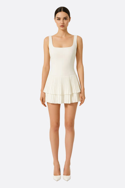 
Détail de la jupe plissée d'une robe courte blanche, offrant une allure chic et moderne pour des occasions élégantes.



