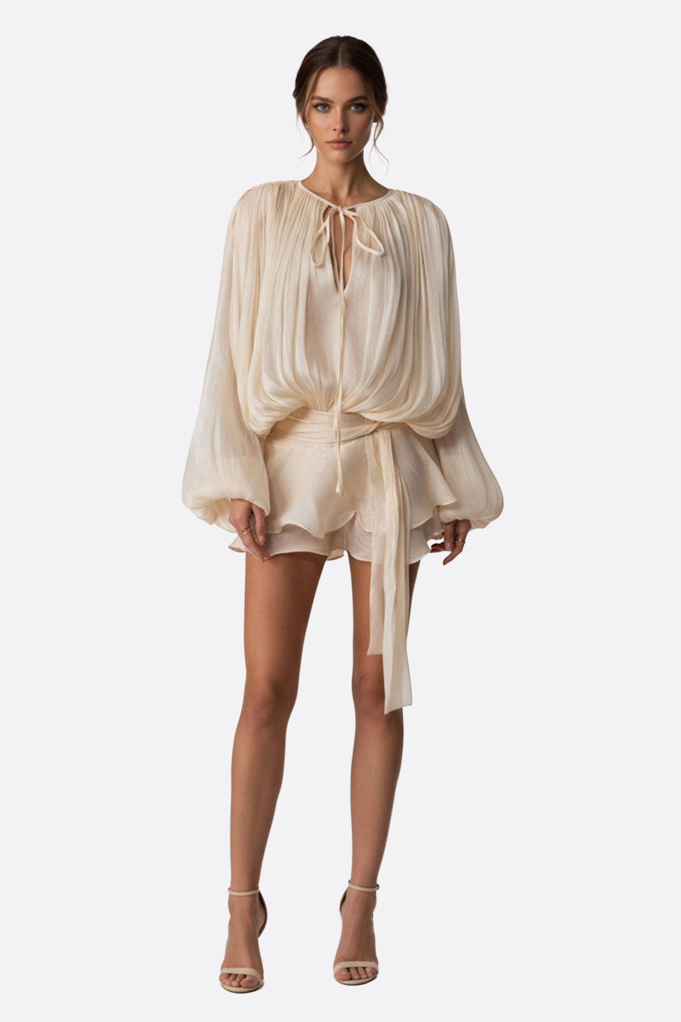 Détail élégant de la robe courte rose poudrée, drapée avec volants délicats, parfaite pour un look raffiné.