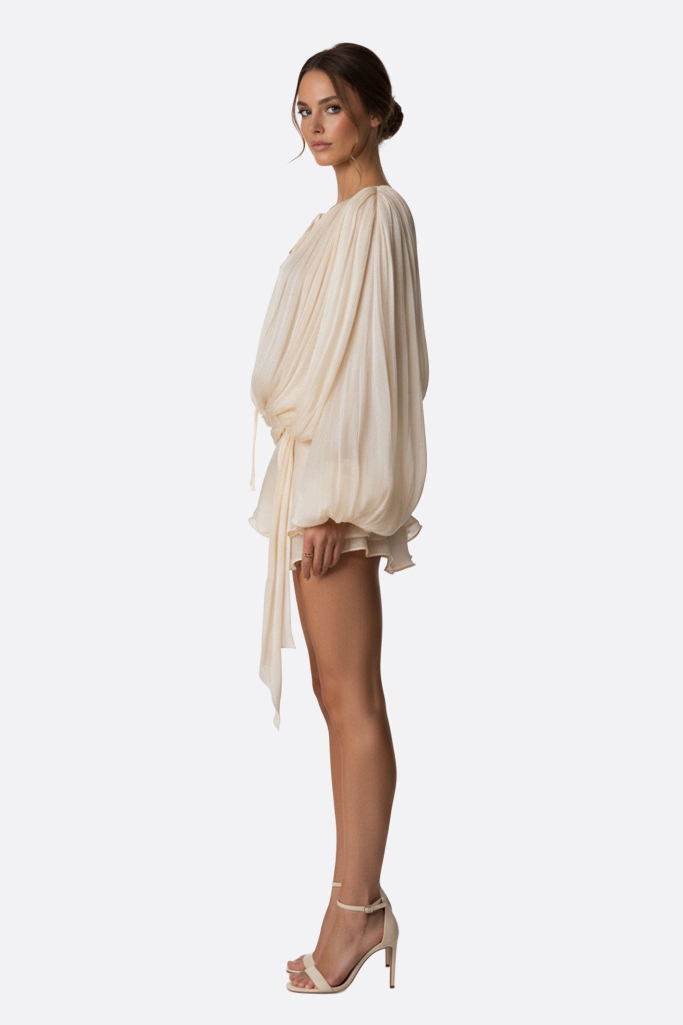 Robe courte rose délicate au drapé fluide et volants, un choix élégant pour une sortie moderne et stylée.