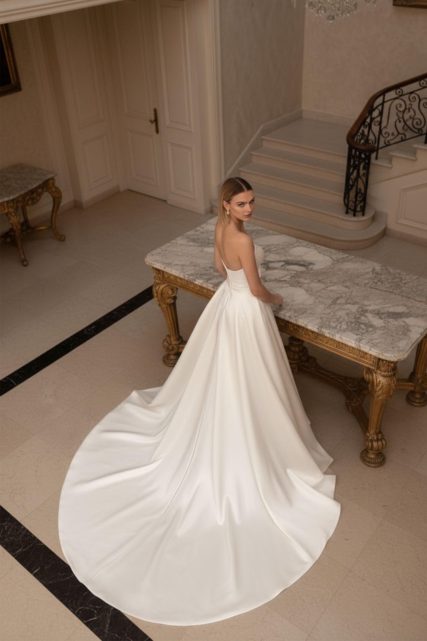 Detalle de la traîne fluida de un vestido de novia largo blanco con bustier, destacando su estilo elegante y refinado...