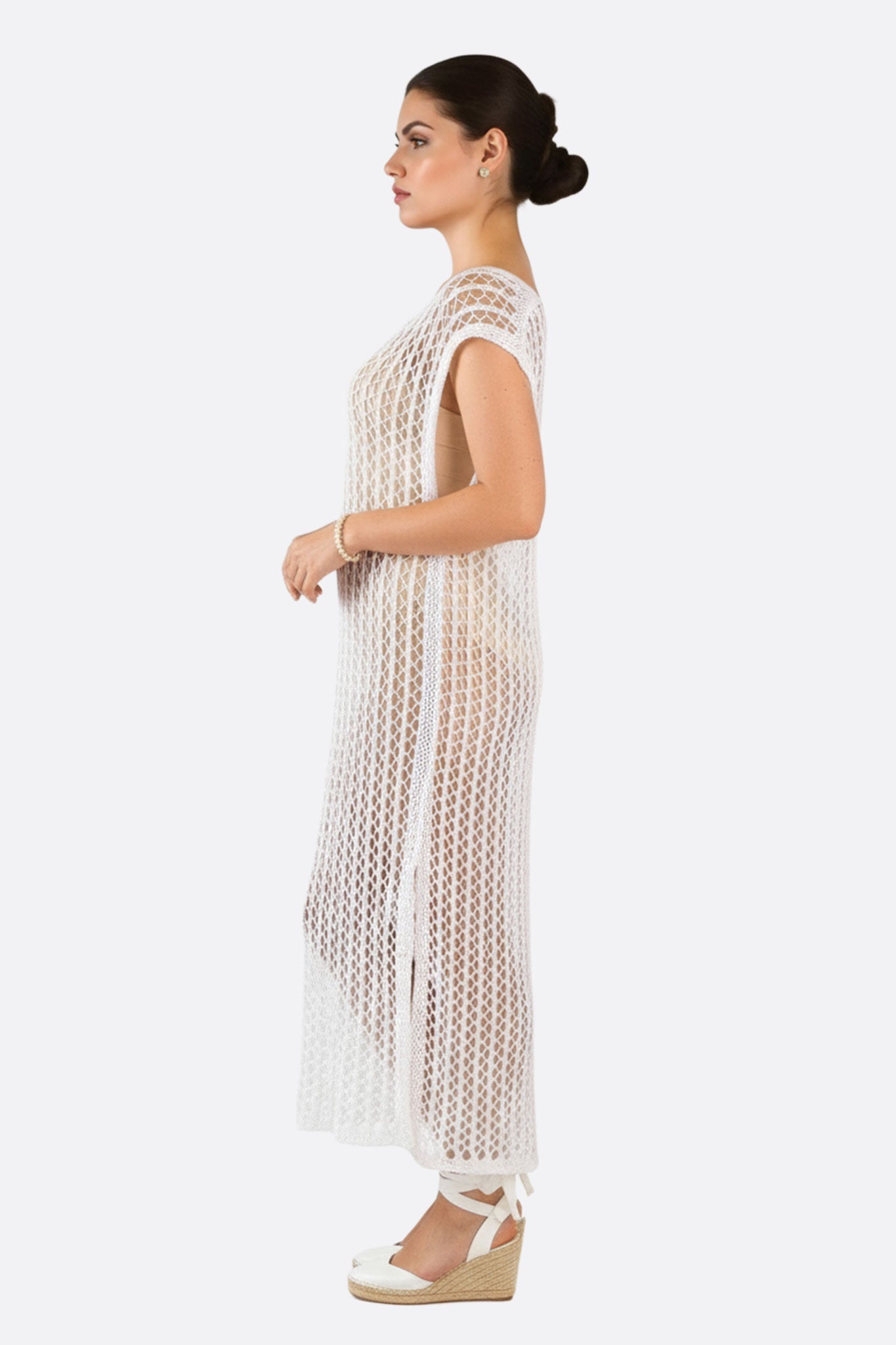 
Détail en maille crochet blanche de cette robe de plage bohème, parfaite pour un style chic et léger sous le soleil.



