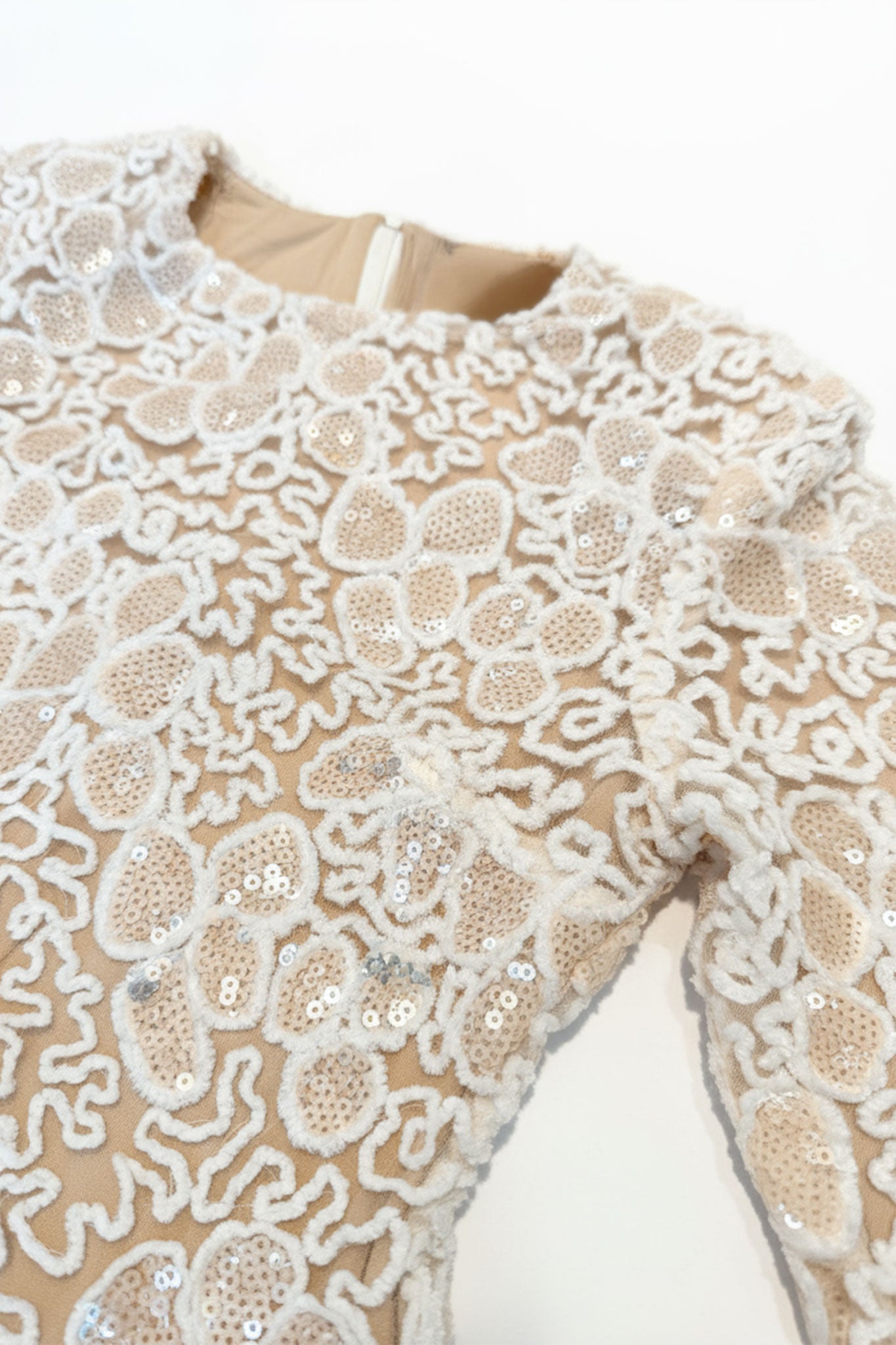 Dettaglio della manica lunga dell'abito lungo bianco in pizzo avorio, ideale per cerimonie eleganti e serate romantiche,...