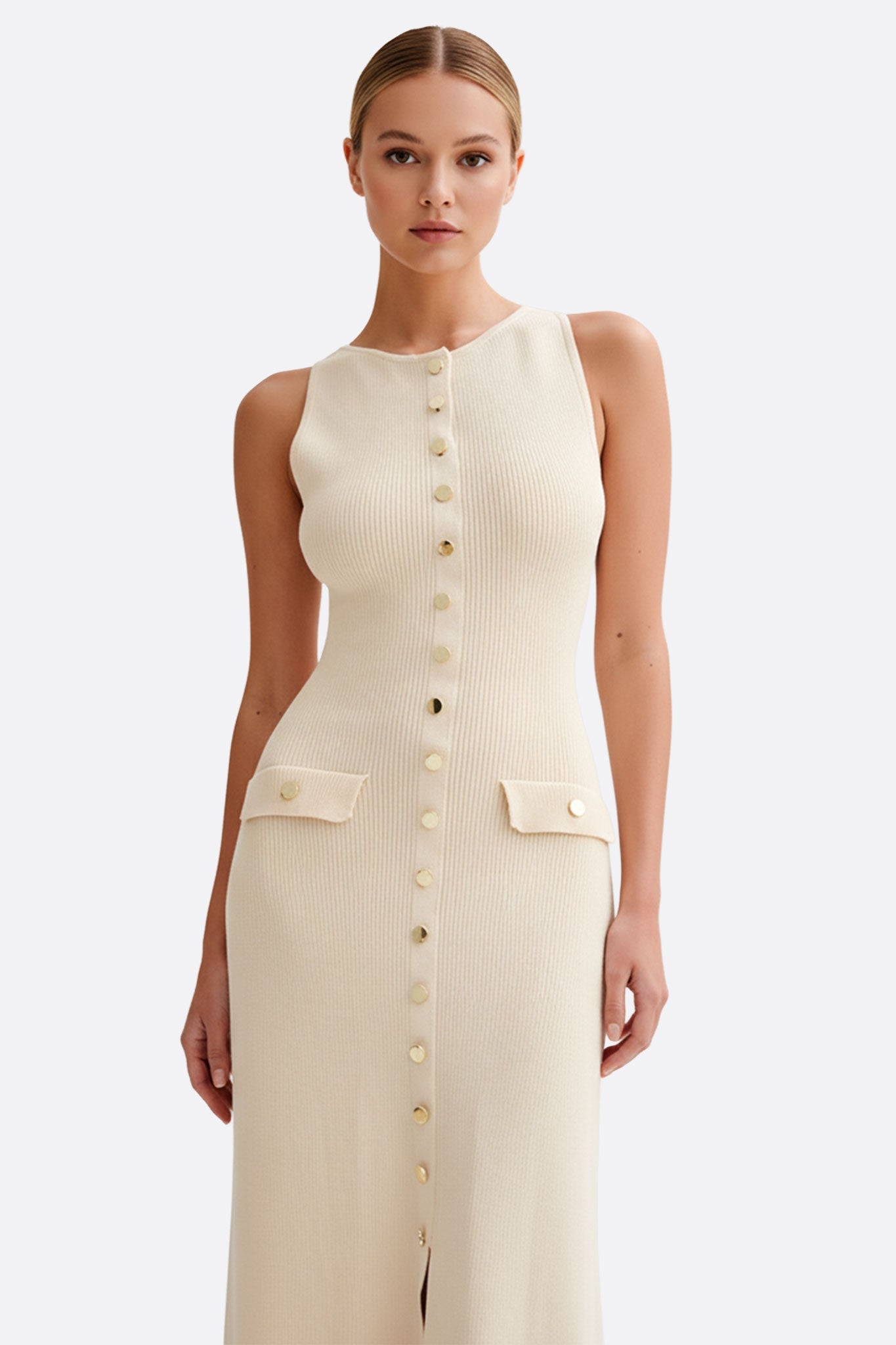 Vestido largo beige sin mangas en punto acanalado, con botones que realzan su estilo elegante y sofisticado.