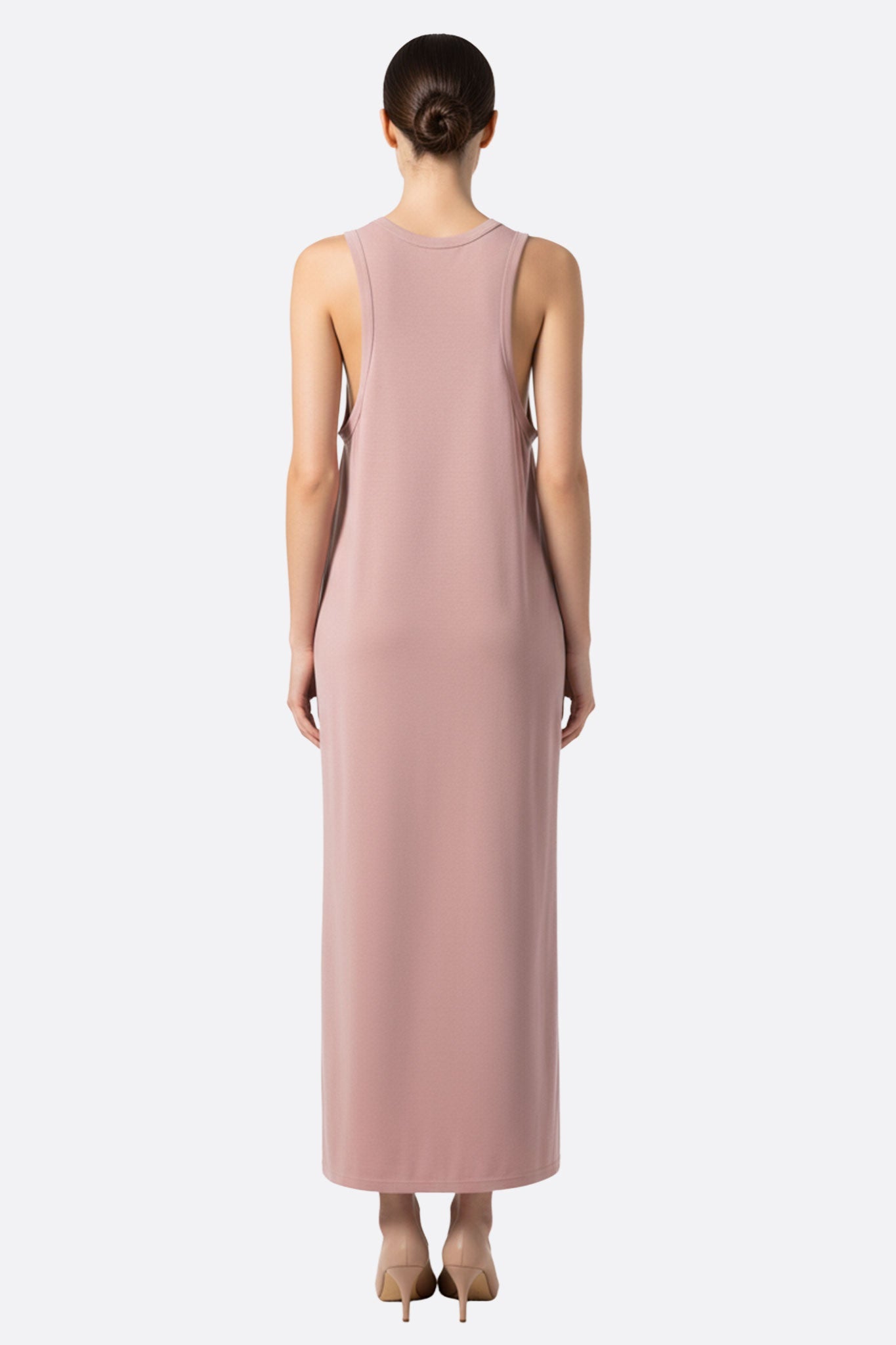 
Détail de la robe longue rose poudré, mettant en avant la texture fluide et l'élégance de son encolure douce.



