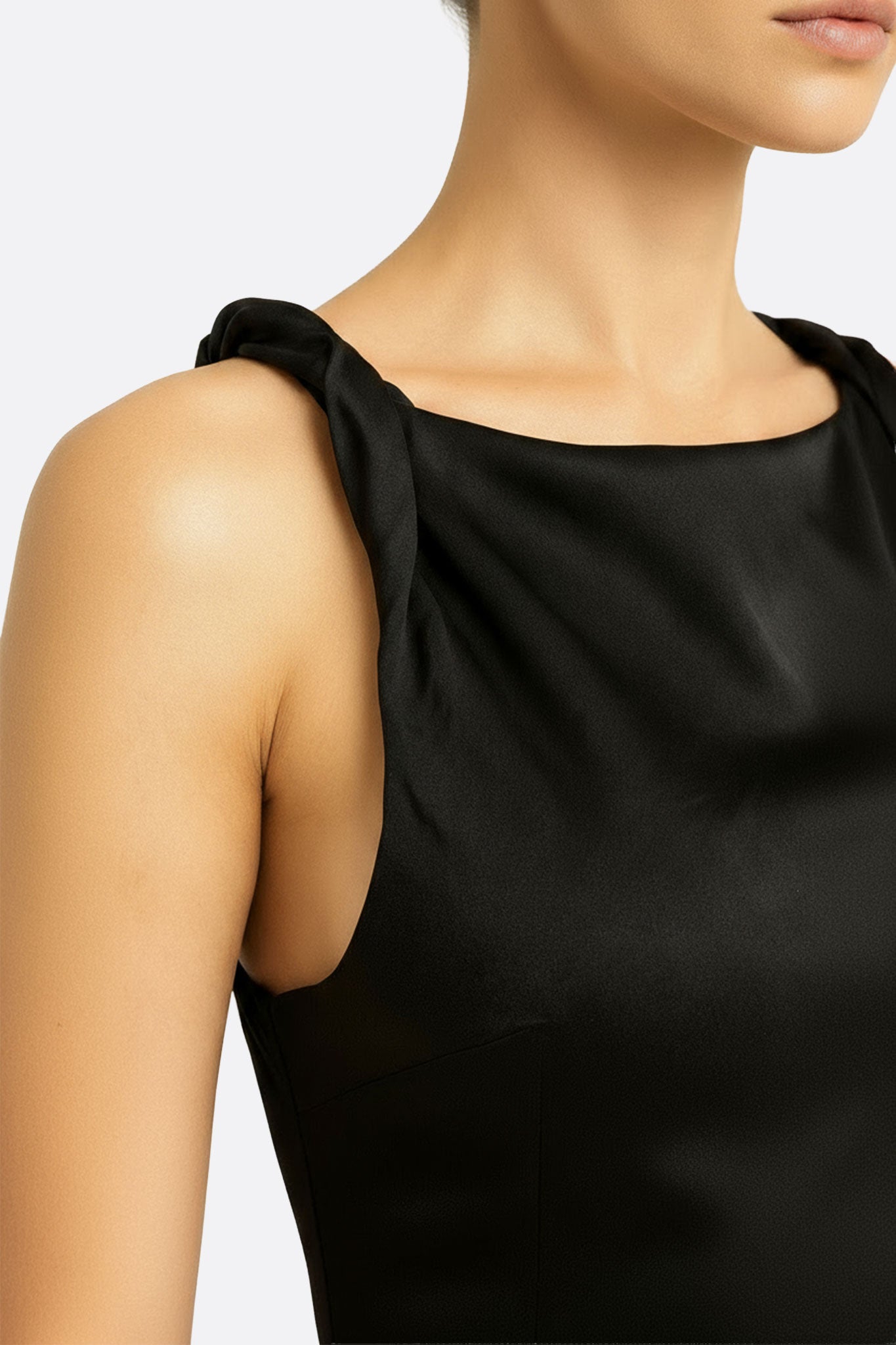 Dettaglio del retro dell'abito lungo in satin nero, mostrando la scollatura americana e la texture satinata che esalta...