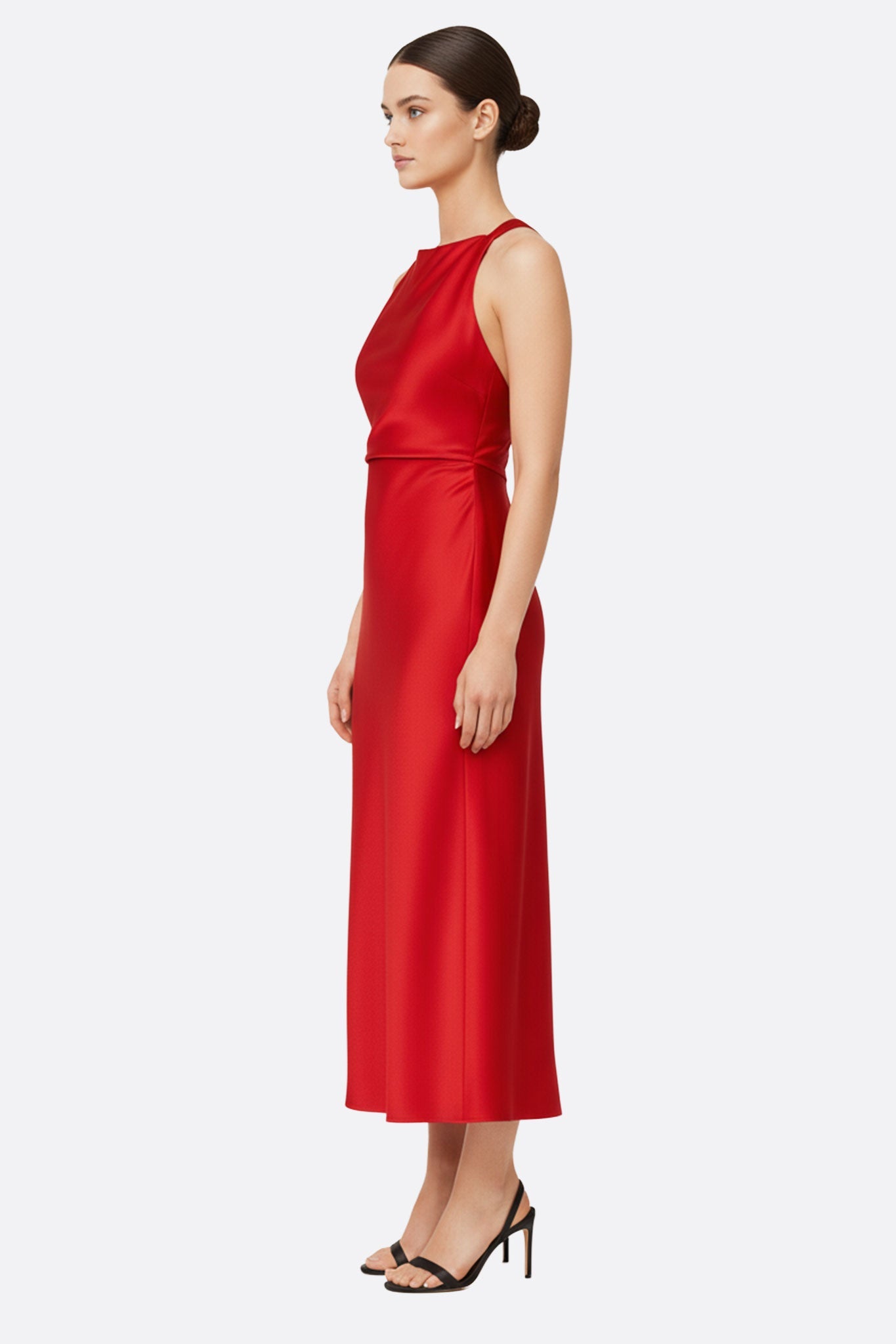 Détail de la robe longue en satin rouge, mettant en avant l'encolure américaine et la fluidité du tissu pour une élégance...
