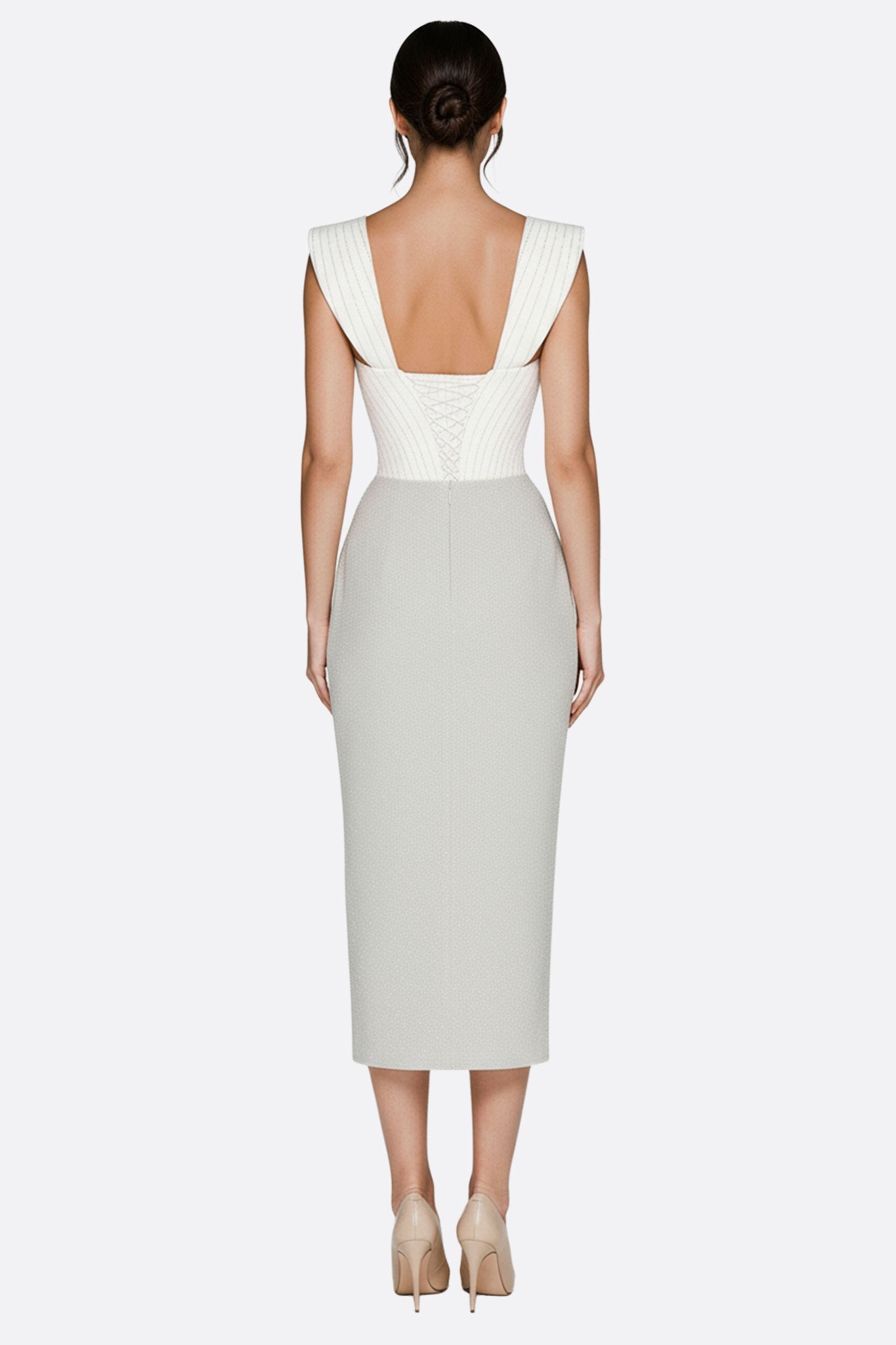 
Détail de la robe midi blanche à corset ajouré, mettant en valeur sa fente frontale pour une silhouette glamour en soirée.



