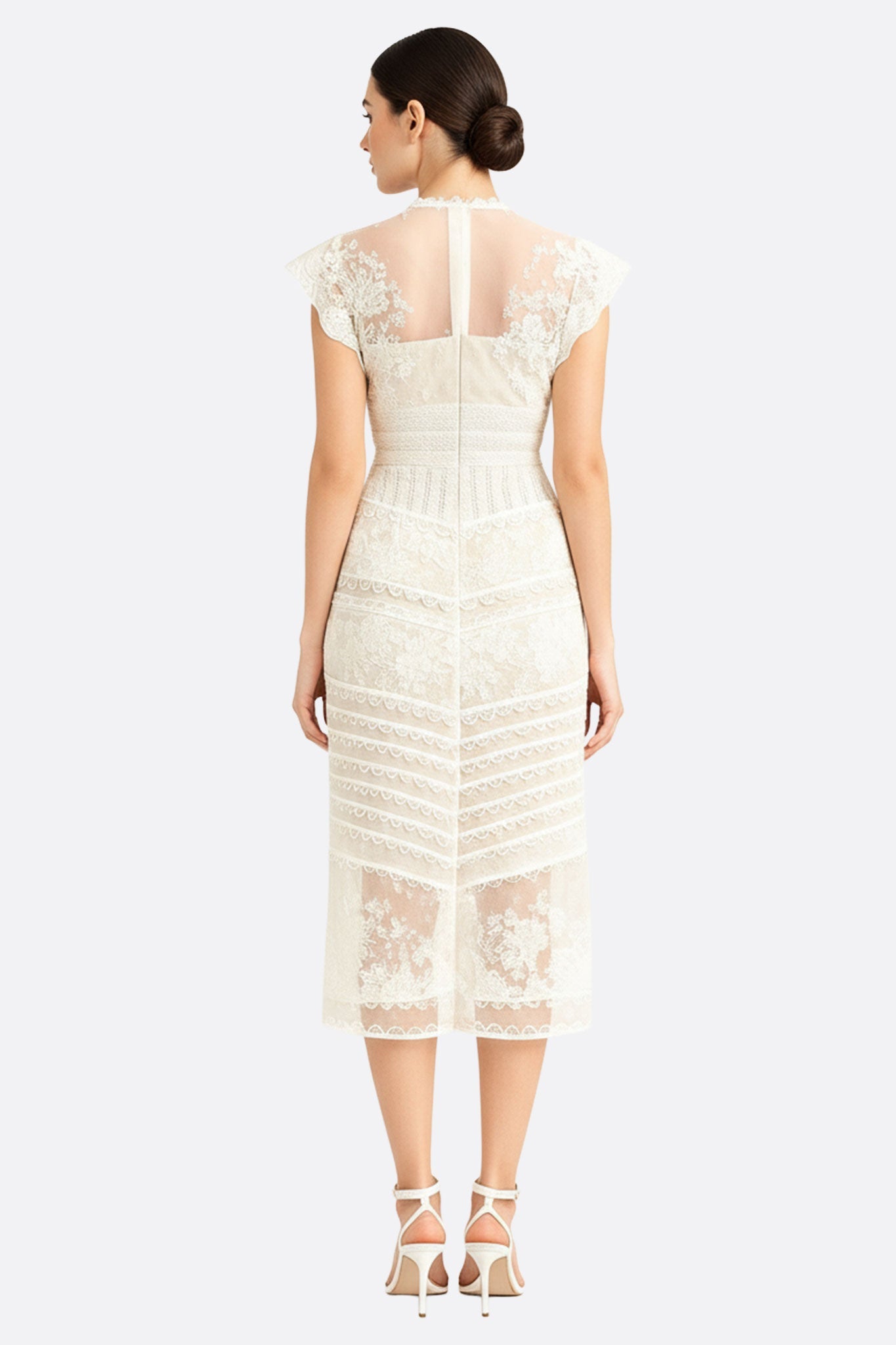 Détail délicat de la robe midi bohème en dentelle blanche, mettant en avant son allure romantique et aérienne.