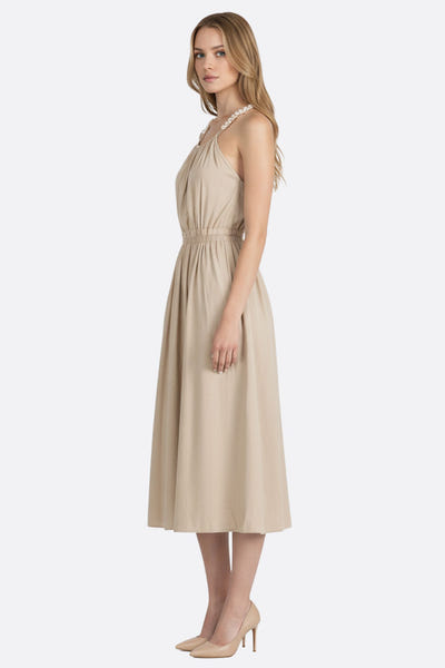 
Zoom sur le dos nu de la robe midi en lin beige avec bretelles perlées, idéal pour une élégante soirée d'été.



