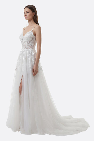
Détail de la robe de mariée en tulle blanc avec fente avant et broderies florales pour un look romantique et raffiné.



