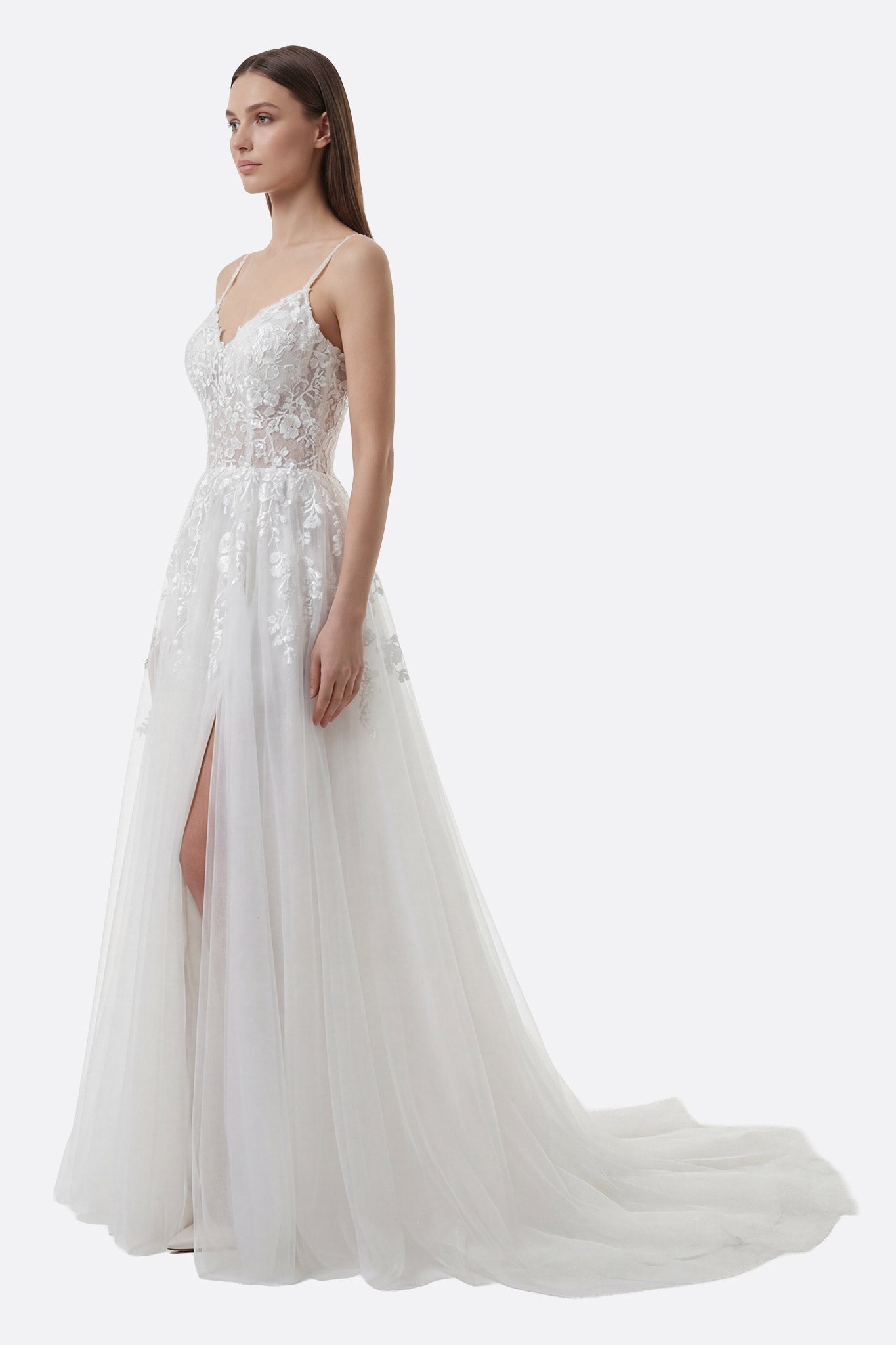 
Détail de la robe de mariée en tulle blanc avec fente avant et broderies florales pour un look romantique et raffiné.



