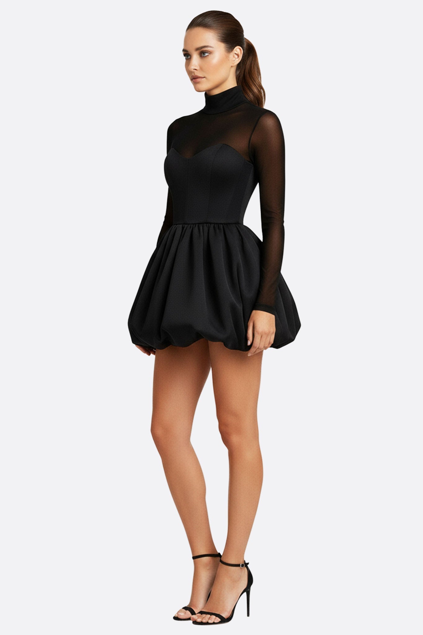 Détail élégant de la robe noire à manches transparentes, en tulle léger, parfaite pour une soirée glamour.