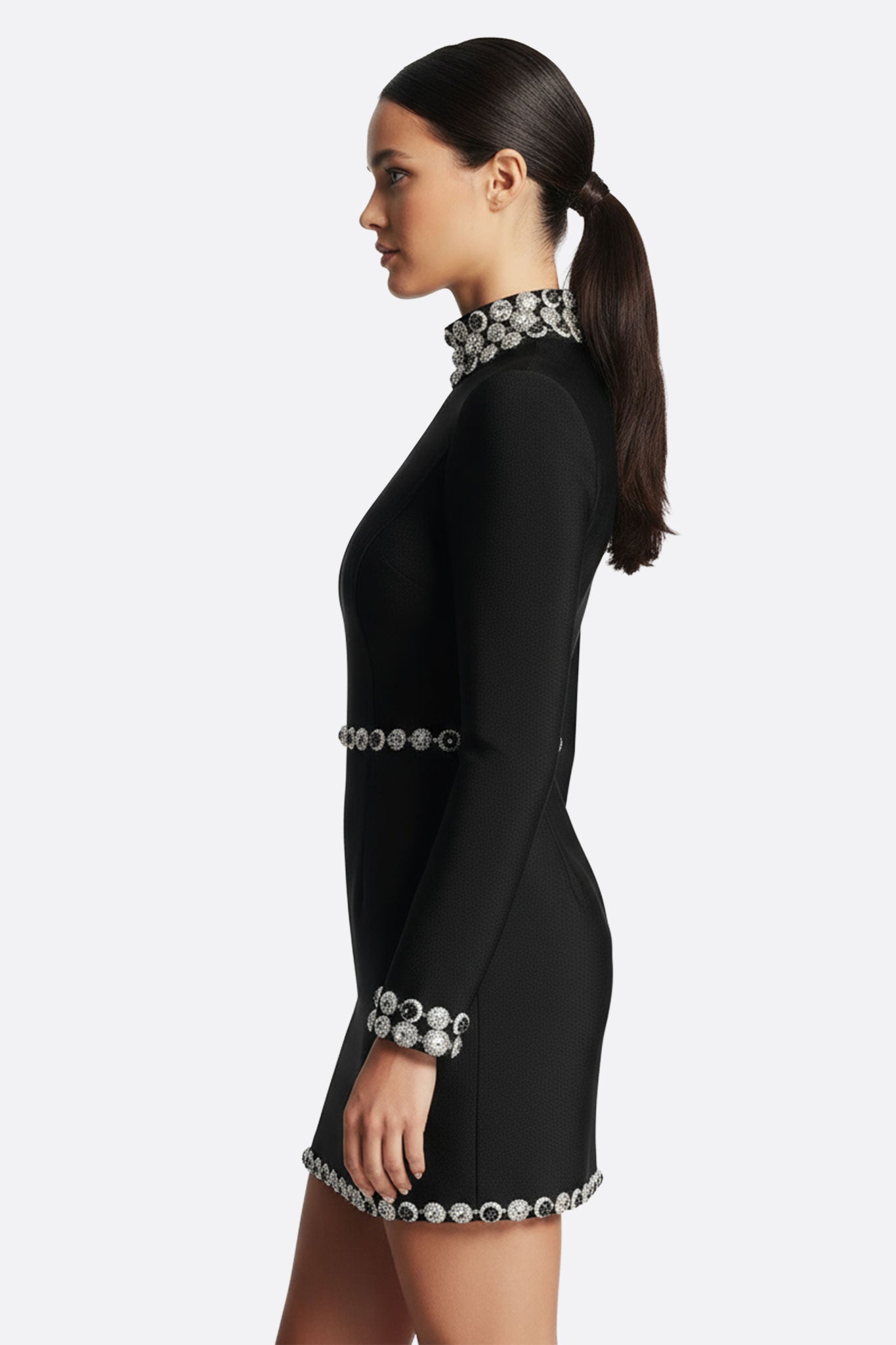 Zoom sur le col bijou orné de cristaux scintillants d'une robe noire à manches longues, idéale pour une soirée élégante.
