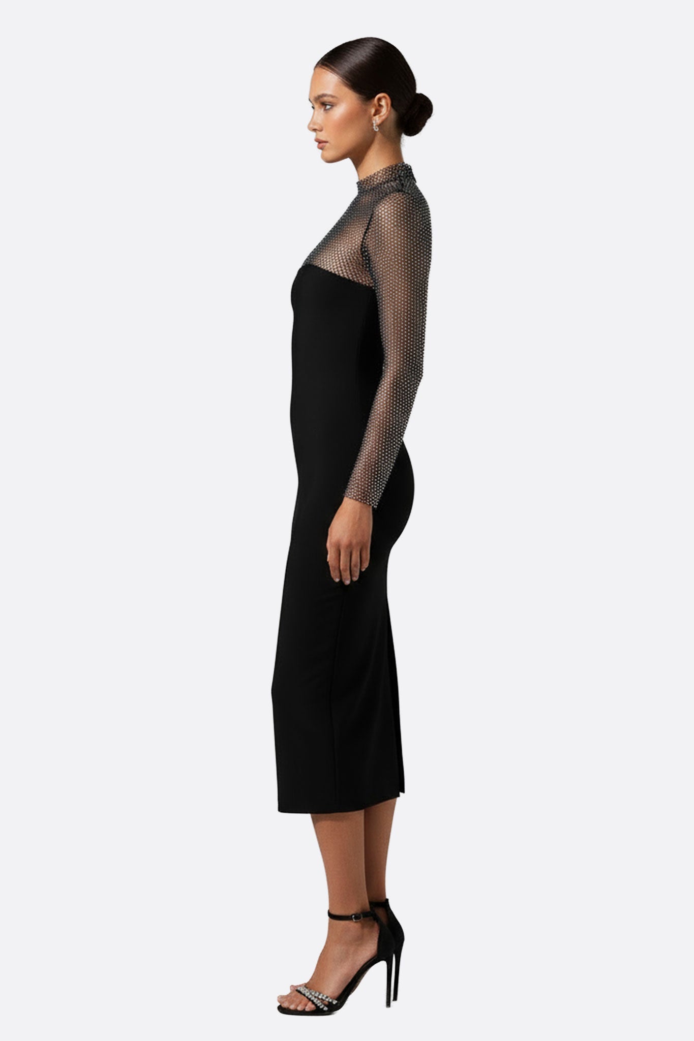 Side angle view of a long black gown with a delicate sheer mesh bodice, ideal for chic soirées or upscale gatherings.