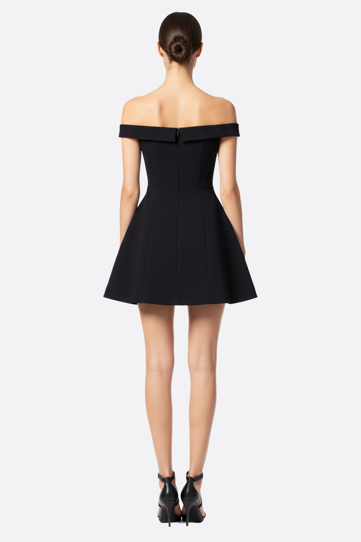 Robe noire à décolleté cœur stylée, mettant en valeur les épaules dénudées, idéale pour une occasion chic et raffinée.
