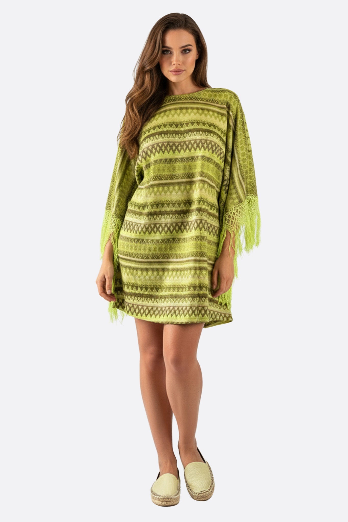 Elegante tunica poncho verde con motivi geometrici, ideale per outfit boho e chic, mostrata frontalmente con dettagli...
