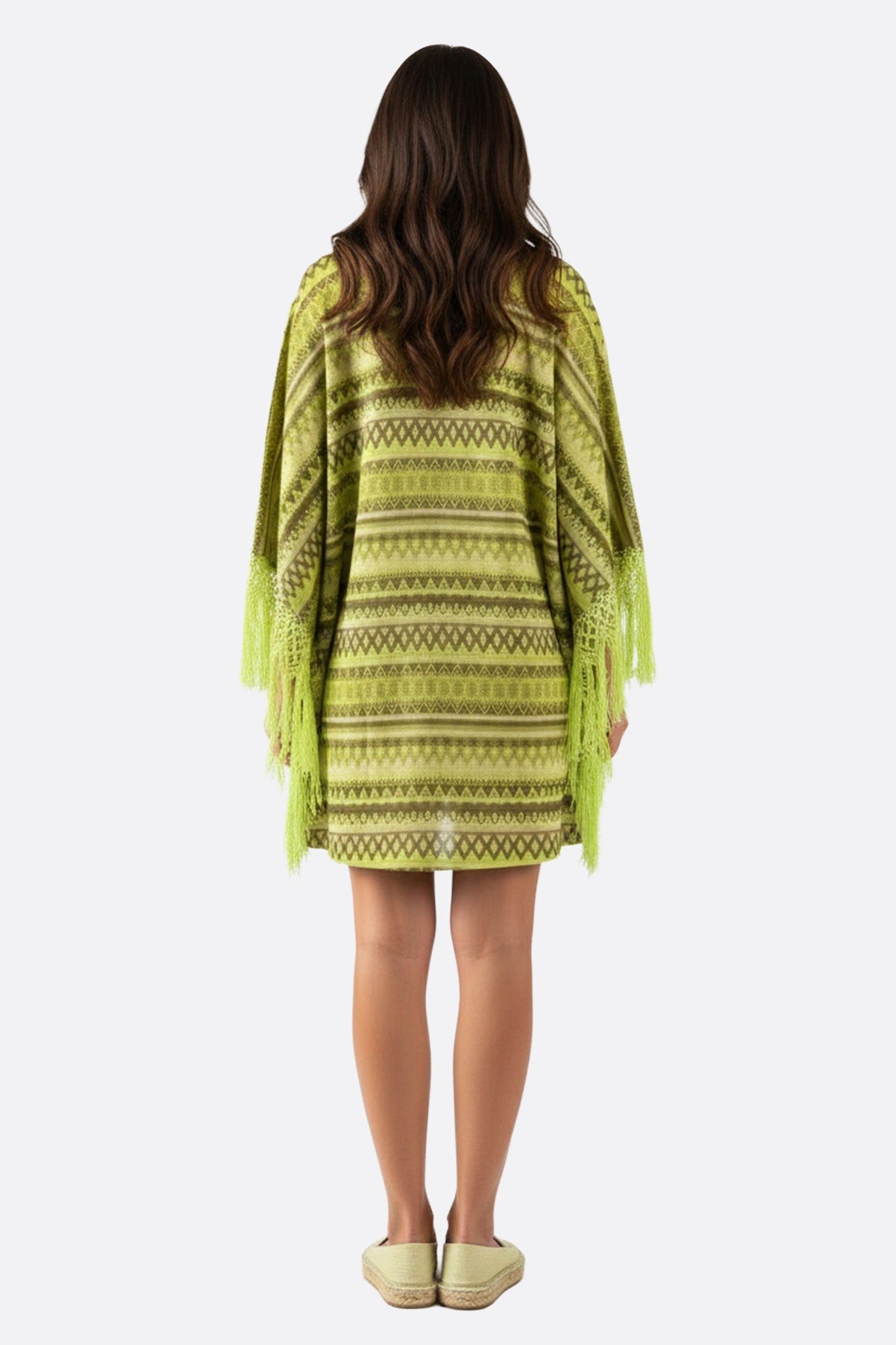 
Détail en gros plan de la robe poncho verte, mettant en valeur ses motifs géométriques raffinés et sa coupe ample.



