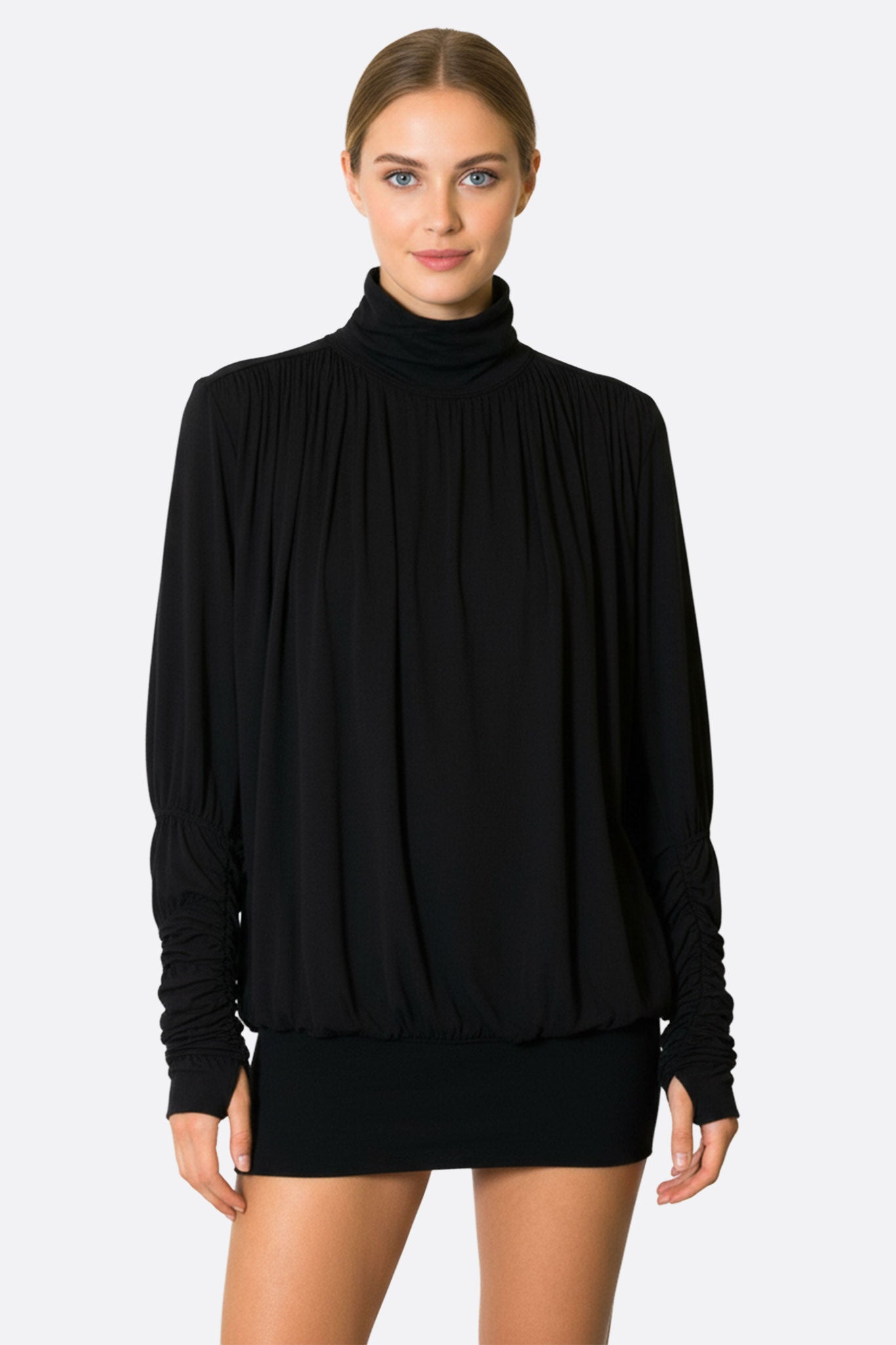 Détail du col montant et des manches froncées de la robe drapée noire, parfaite pour une sortie élégante ou un dîner...