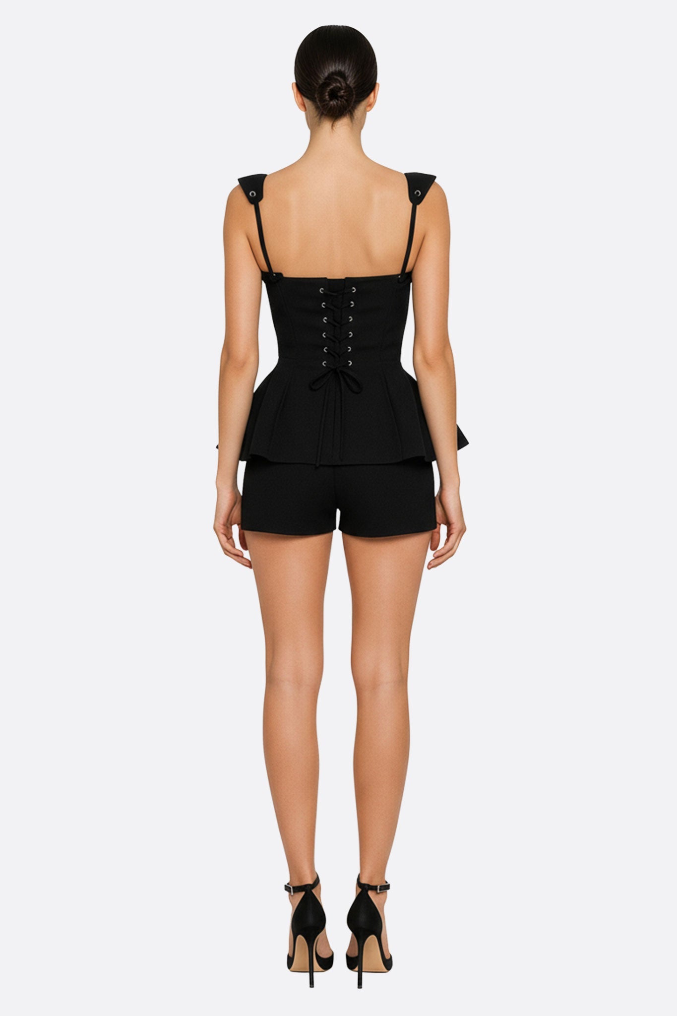 
Perspective alternative de la robe noire à volants, mettant en valeur son design structuré et son allure sophistiquée.



