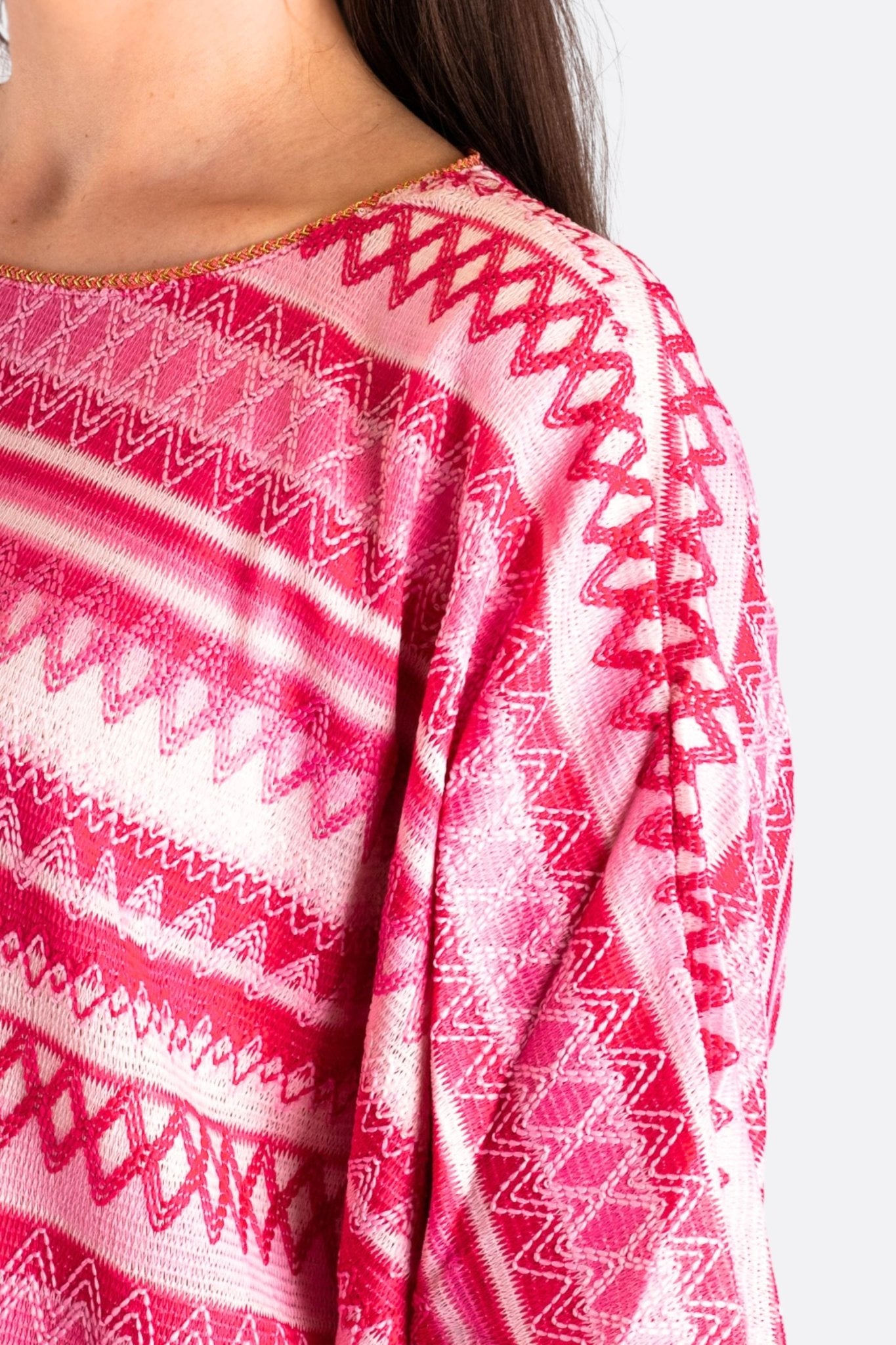 Dettaglio della tunica in maglia jacquard rosa, un capo versatile ideale per occasioni speciali e look eleganti.
