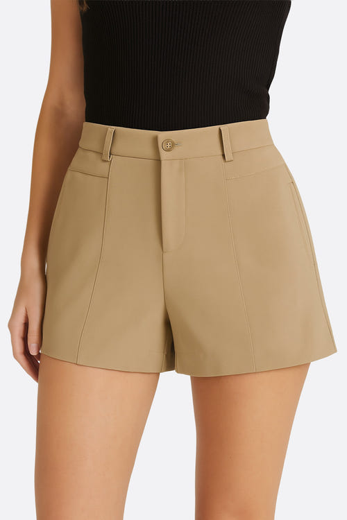 
Détail de la taille haute du short beige à pinces, un incontournable pour un look estival sophistiqué.




