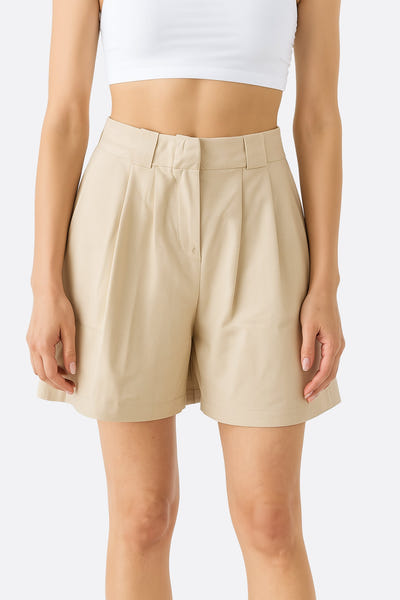 
Zoom sur le short beige taille haute en tencel et lin, mettant en avant sa coupe élégante et sa légèreté idéale pour l'été.




