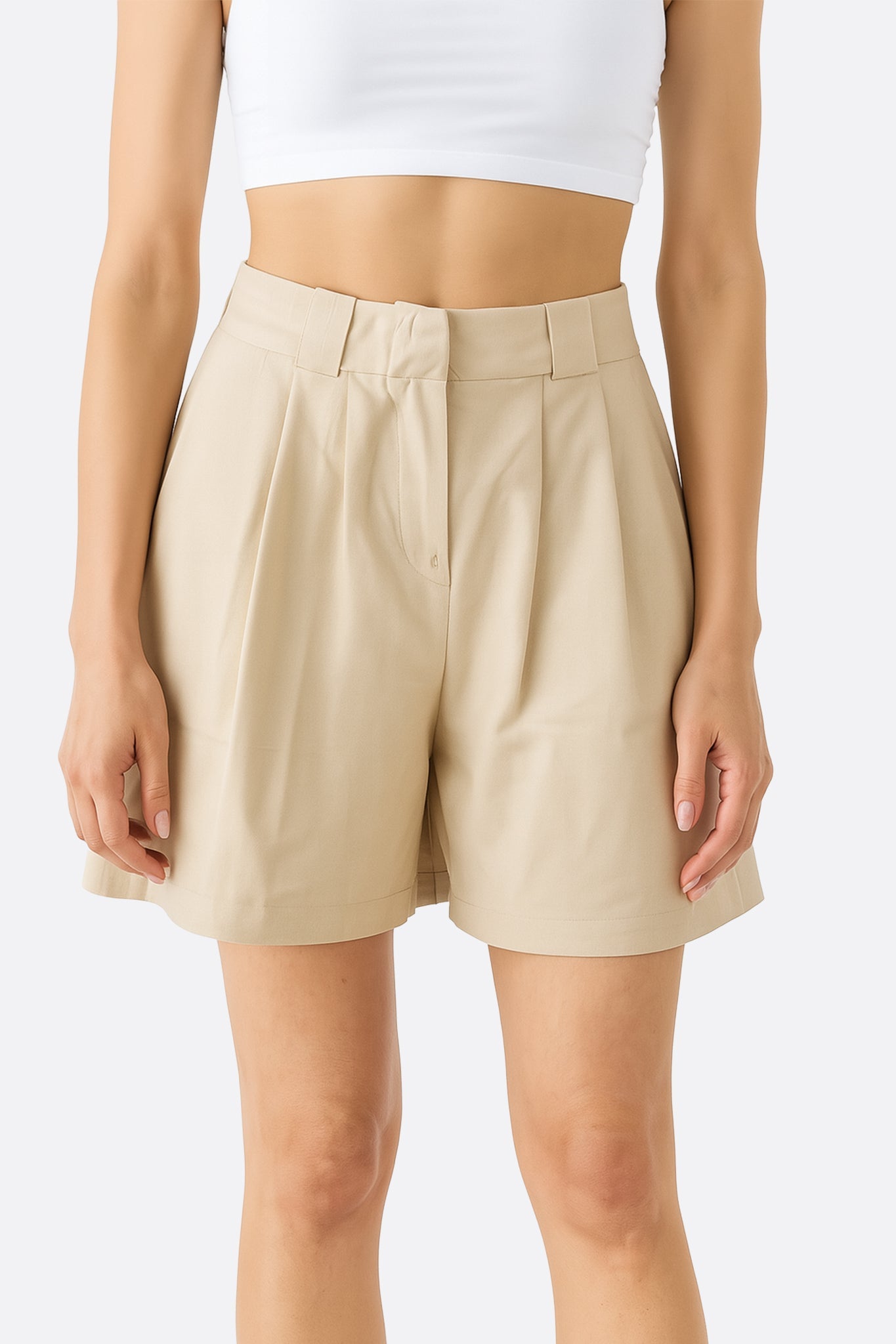 Zoom sur le short beige taille haute en tencel et lin, mettant en avant sa coupe élégante et sa légèreté idéale pour l'été.