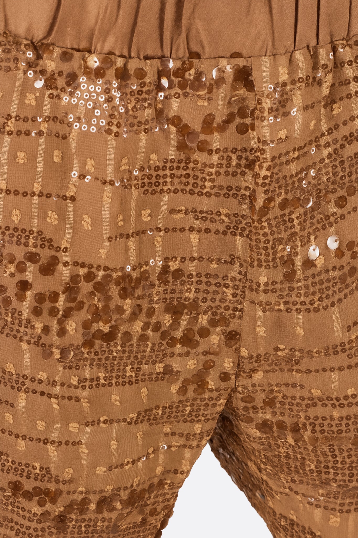 
Détail du short camel orné de sequins bronze, une pièce brillante idéale pour compléter vos tenues de soirée élégantes.



